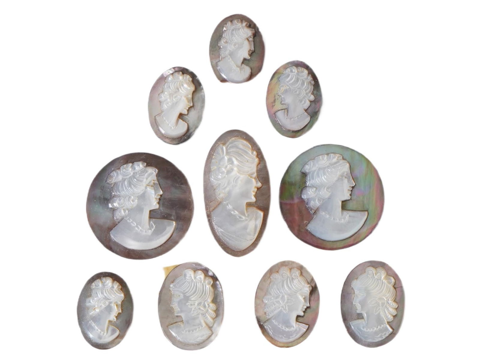 COLLECTION OF FEMALE PORTRAIT HAND CARVED SHELL CAMEO: A collection of ten antique and vintage hand carved cameo medallions. Each piece is crafted from conch shell featuring female portraits in the Victorian manner rendered in high relief. The cameos are