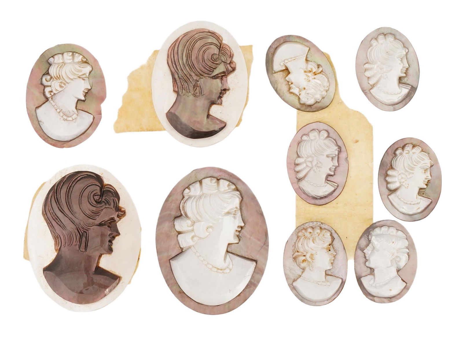 COLLECTION OF ANTIQUE HAND CARVED CAMEOS: A collection of antique hand carved cameos, dating back to the early 20th century. A total of 10 items. Each piece is crafted from conch shell, featuring female profile portraits rendered in high reli
