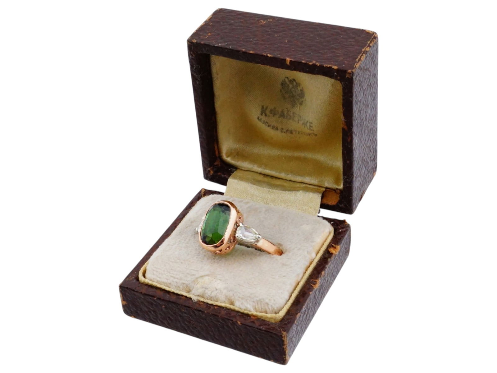 RUSSIAN 56K GOLD AND DIAMOND RING W TOURMALINE: A Russian Gold and diamond jewelry ring. The ring is encrusted with a large green oval Tourmaline stone to the center and two small diamond stones on the sides. The ware is adorned with a foliate scro