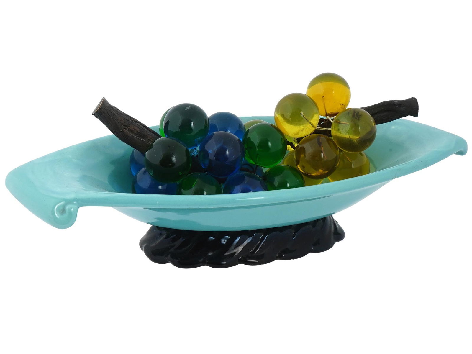 MID CENTURY AMERICAN GLAZED CERAMIC FRUIT BOWL: A vintage mid century American glazed ceramic Fruit Bowl with two bunches of grapes. A blue vase, elongated in shape with curled edges, on a black relief stand with a hole in the middle. Grape cluster