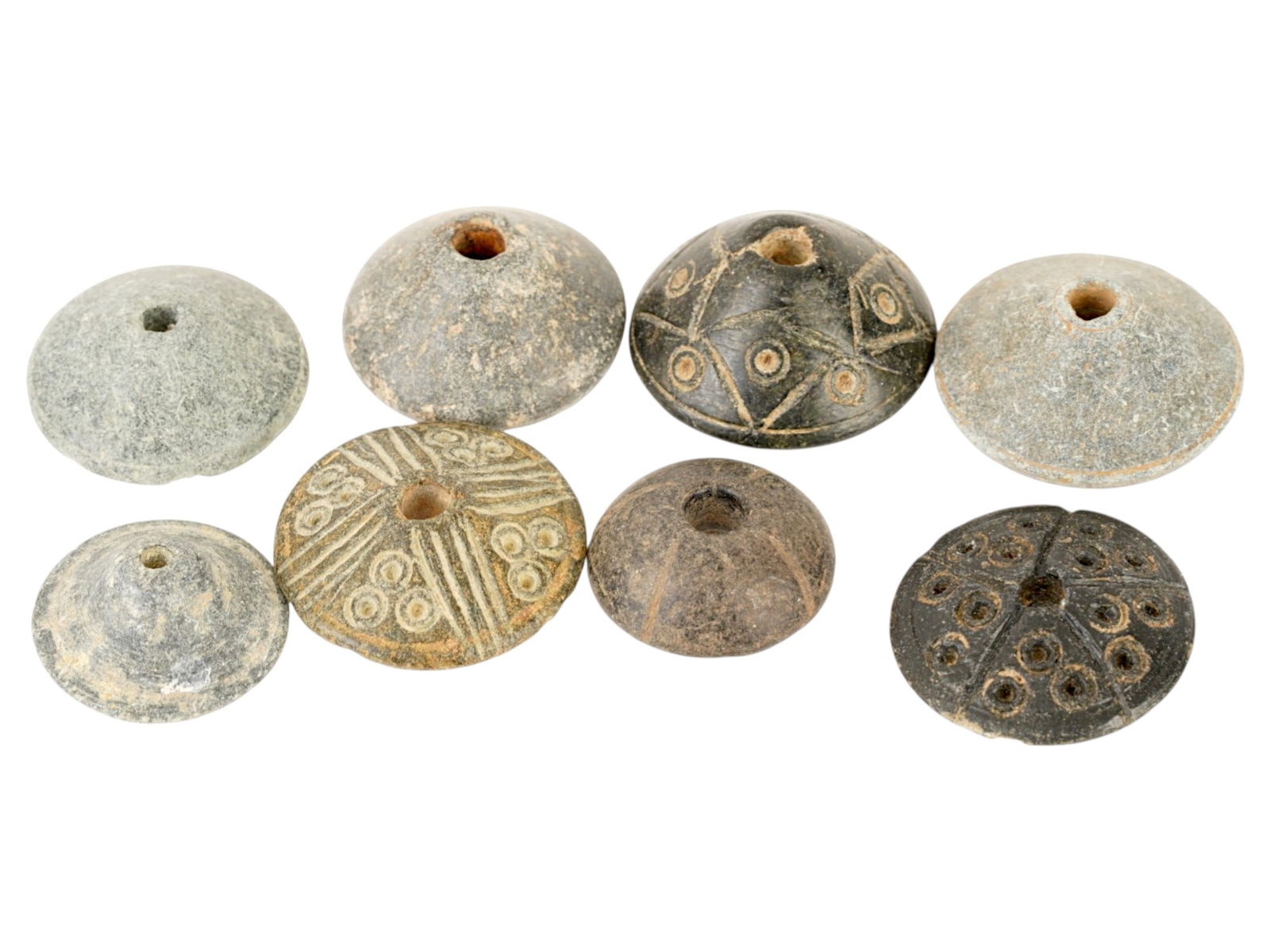 8 ANCIENT HOLY LAND SPINDLE WHORLS 300 BC TO 400 AD: A group of eight ancient Holy Land spindle whorls. Circa 300 BC to 400 AD. All the items are nearly the same shape, round with a hole in the middle, some are decorated with an engraved pattern with sm
