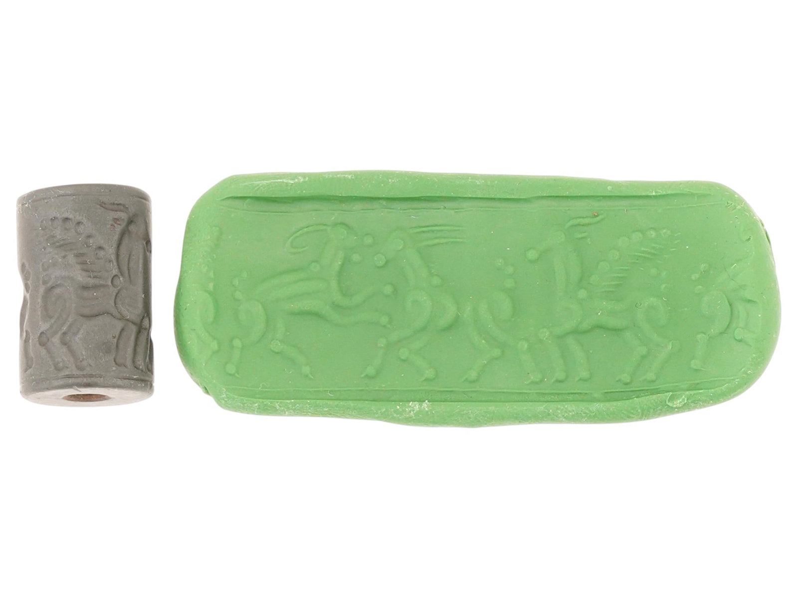 ANCIENT WESTERN ASIATIC HEMATITE RUNNING ANIMALS BEAD: An ancient Western Asiatic hematite bead, dating to the 1st millennium BC. Engraved with running mythological animals. Carved from dark hematite, the bead features symbolic motifs connected to religio