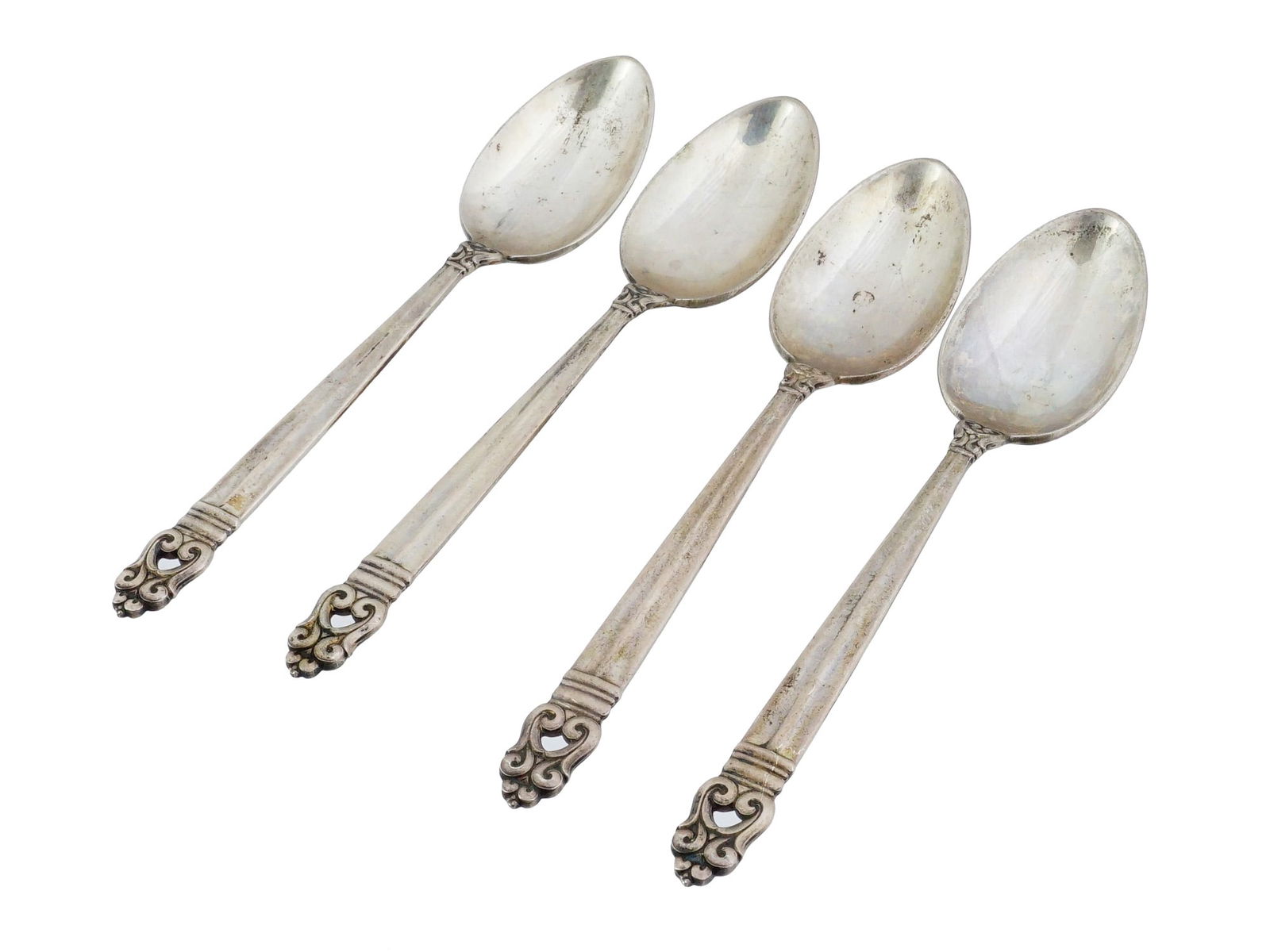 VINTAGE INTERNATIONAL SILVER SILVER SPOONS ROYAL DANISH: A set of four vintage American sterling silver spoons in the Royal Danish pattern by International Silver Company. The handles feature an openwork scroll and floral terminal, characteristic of the