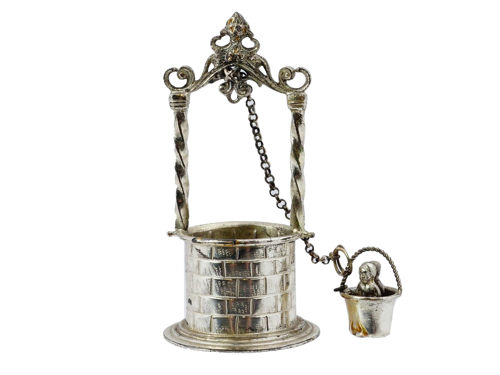 ANTIQUE MINIATURE SILVER WISHING WELL CHILDREN BUCKET: An antique miniature silver wishing well, showing a detailed collectors piece and depicting two children seated in a suspended bucket. Features a brick-patterned base, ornate supports, and a