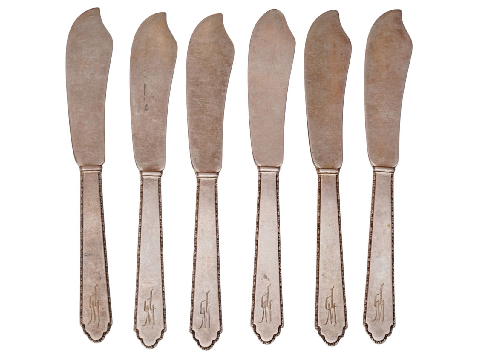 SET OF SIX BUTTER STERLING SILVER SPREADERS KNIVES: A set of six butter spreaders featuring weighted sterling silver handles and stainless steel blades. Each handle is designed with a classic tapered terminal accented by a simple linear border, while