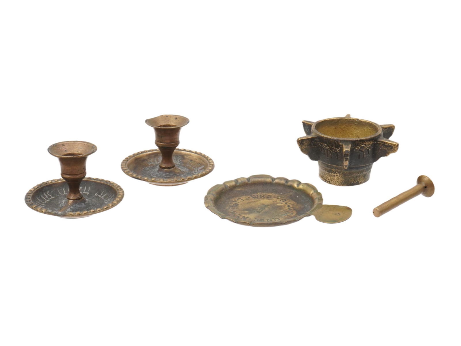 JUDAICA BRASS DECORATIVE OBJECTS CANDLESTICKS: A collection of antique and vintage brass decorative objects, including a pair of short ornate candlesticks with drip pans reminiscent of 19th-century Eastern European chamberstick designs, a miniatur