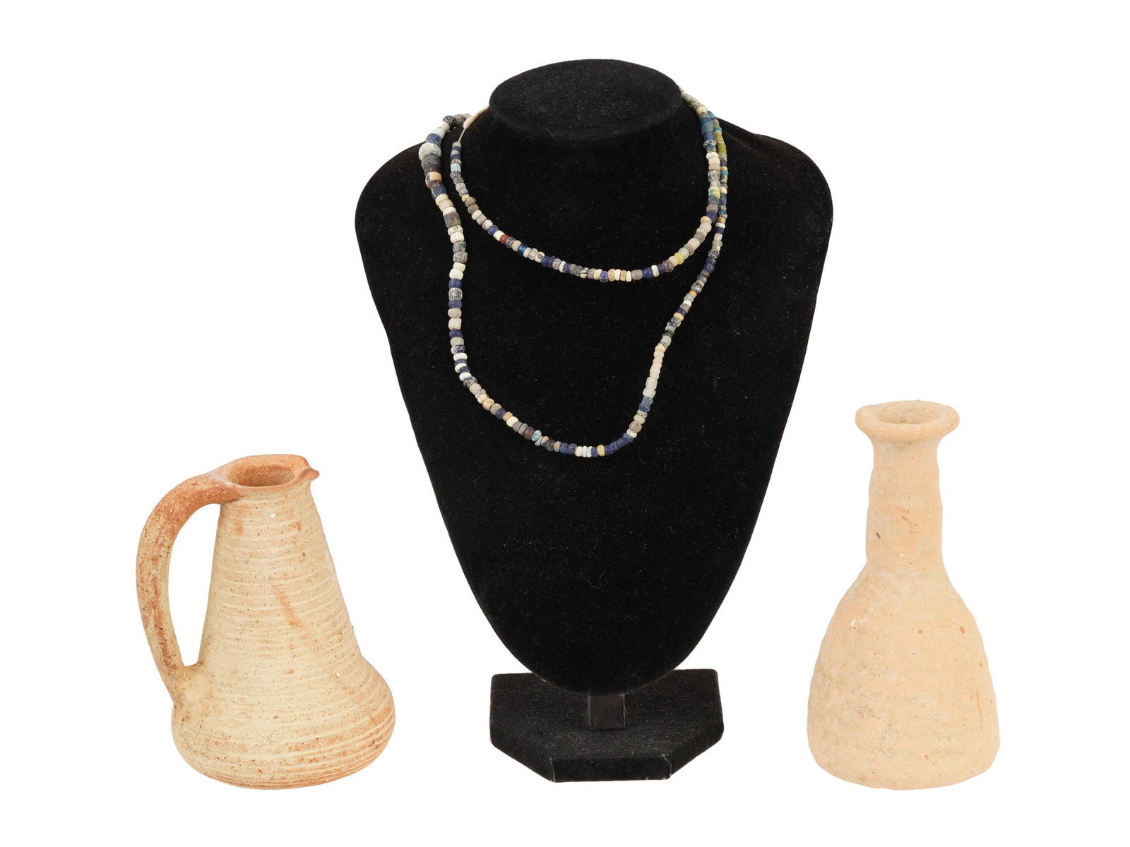 ANCIENT ROMAN TERRACOTTA WINE PITCHERS BEAD NECKLACE: A group of ancient Roman terracotta wine pitchers, dating to approximately 100 to 300 AD, accompanied by an ancient glass bead necklace. The pitchers, formed in clay with simple yet functional shapes,