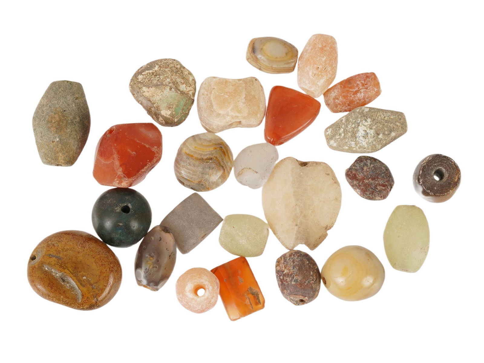ANCIENT AGATE CARNELIAN STONE BEADS OF VARIOUS SHAPES: A group of ancient agate, carnelian, and related stone beads of various shapes, dating to the 1st millennium BC. Comprising a varied assortment of polished semi-precious stones in natural earth tones.