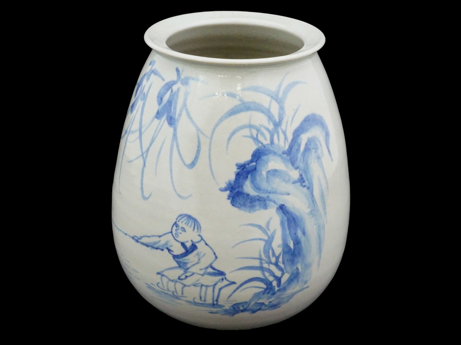 JAPANESE HAND PAINTED PORCELAIN VASE: A Japanese porcelain vase of ovoid form is decorated in underglaze blue with a continuous scene depicting a fisherman seated among trees and stylized waves. The vessel features a short flared rim and