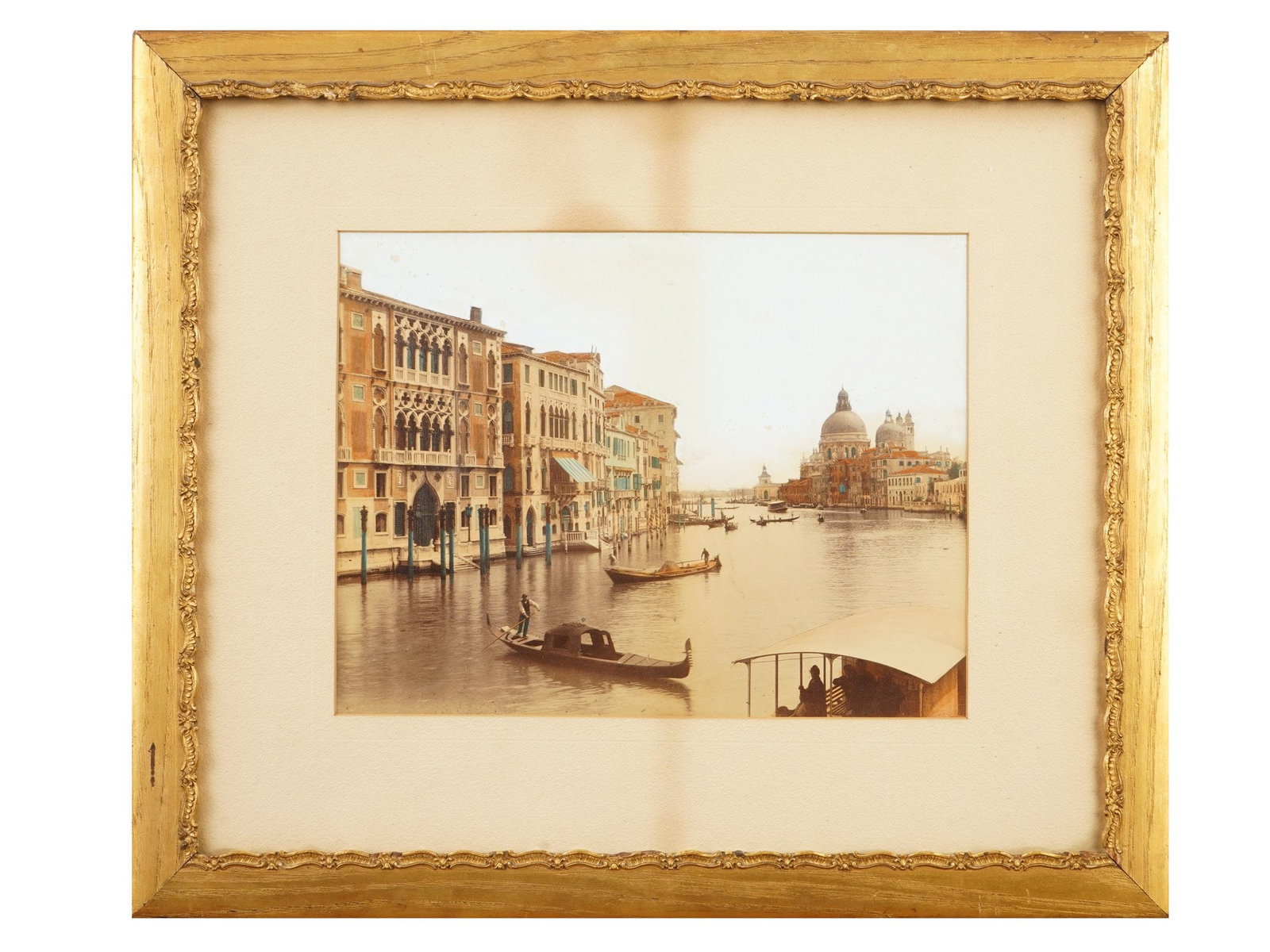 HAND COLORED PHOTO PRINT OF THE GRAND CANAL IN VENICE: A hand-colored photo print of the Grand Canal in Venice, Italy. The view looks down the Grand Canal toward the iconic dome of Santa Maria della Salute in the distance. Inscribed H. E. Hutchinson, 212