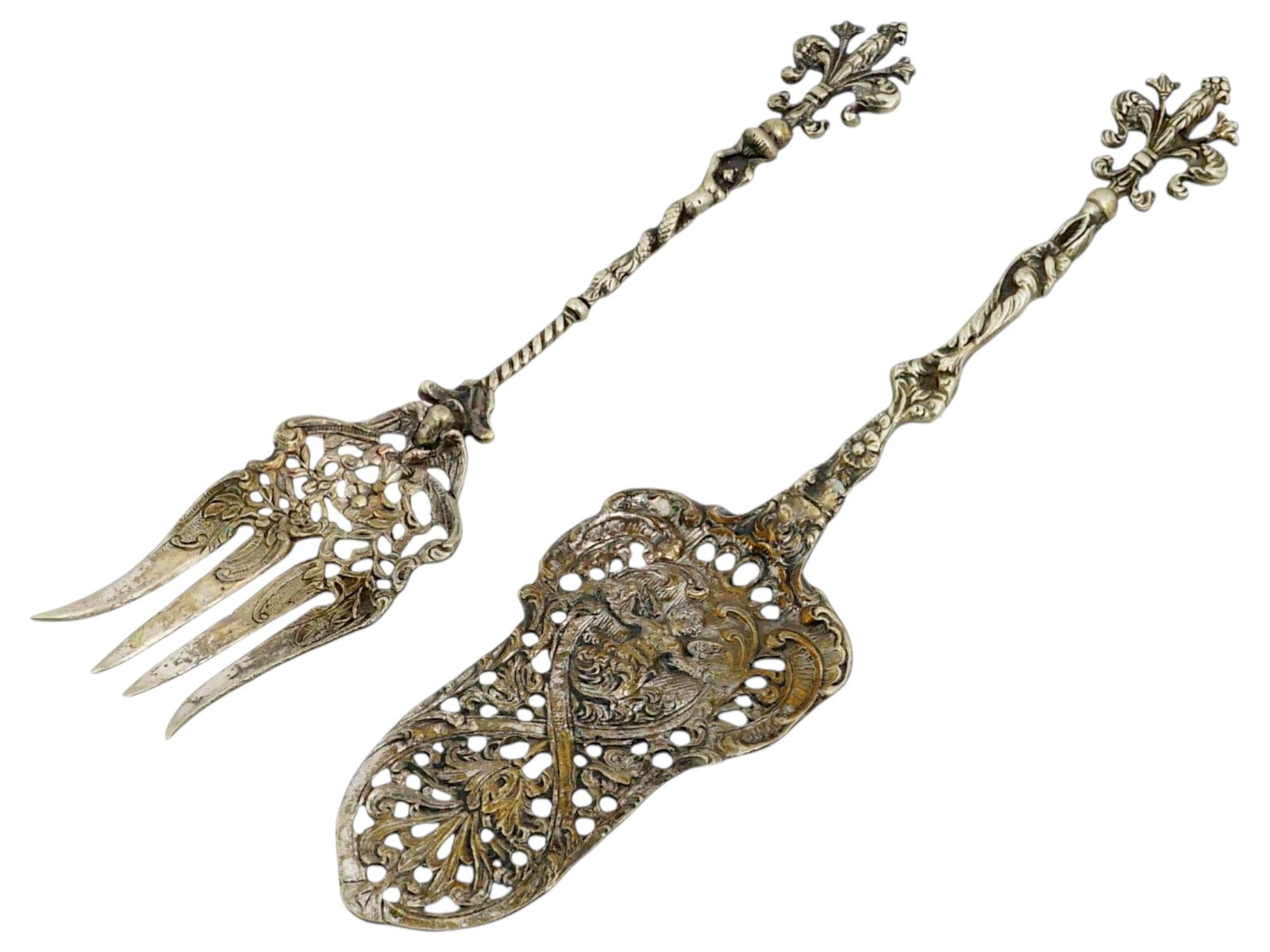 ITALIAN RENAISSANCE STYLE SERVING SET OF SERVER AND FORK: An Italian serving set consisting of a pierced pastry server and a large cold meat fork, crafted in the Baroque or Neo-Renaissance style. Each piece features a highly decorative handle characterized b