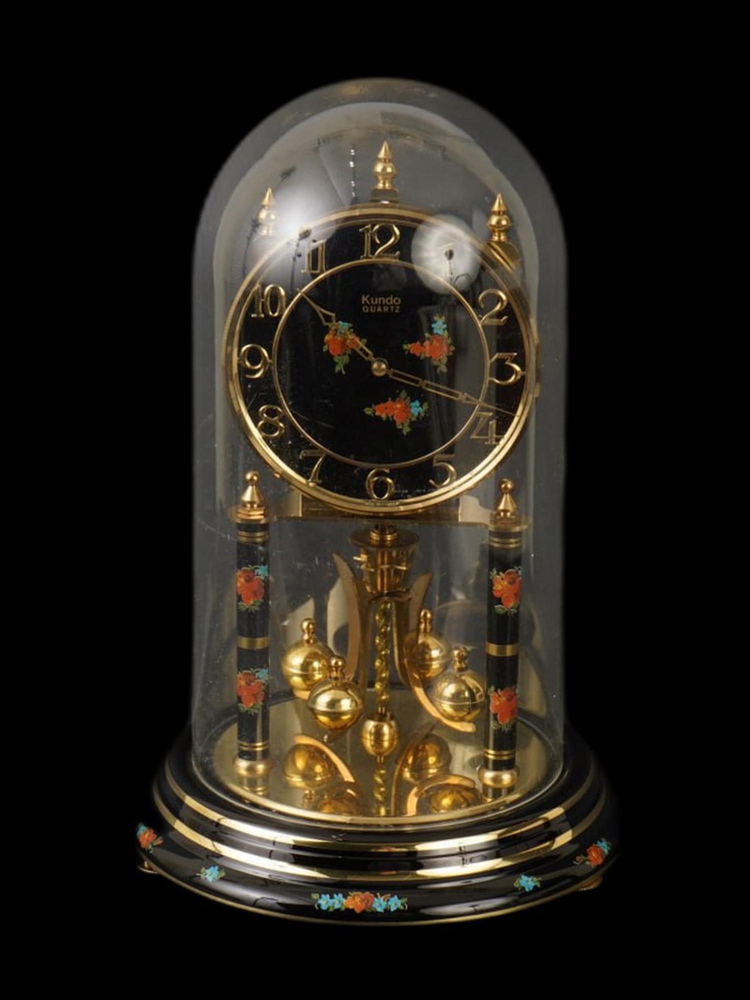 VINTAGE GERMAN KUNDO QUARTZ ANNIVERSARY TORSION CLOCK: A vintage German Kundo Quartz Anniversary torsion clock, a decorative timepiece characterized by its rotating torsion pendulum and protective dome. This specific model features a black face and base a