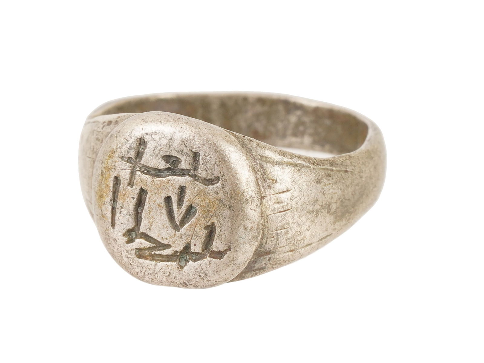 ANCIENT HOLY LAND SILVER SIGNET RING CA 700 TO 900 AD: An ancient Holy Land silver signet ring, circa 700 to 900 AD. The piece features a circular bezel deeply engraved with an Islamic inscription. The band tapers slightly from the shoulders to the base a