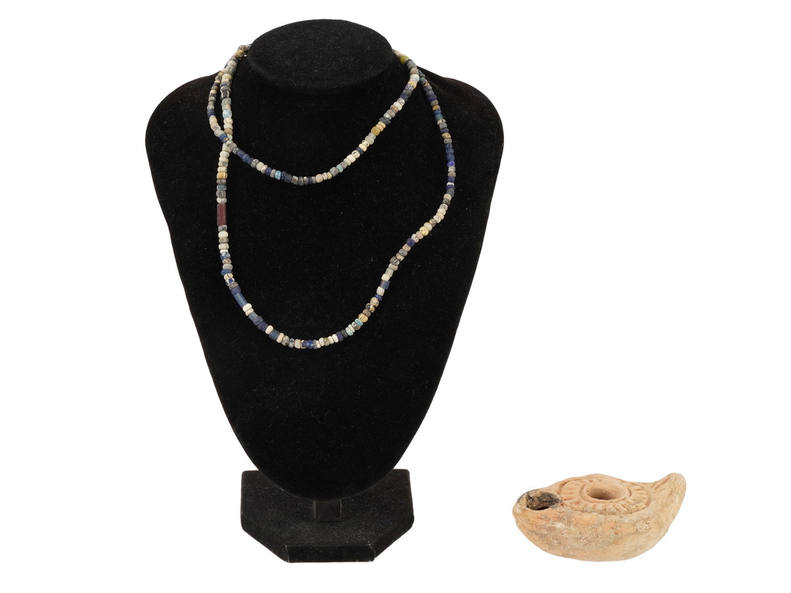 ANCIENT ROMAN GLASS BEAD NECKLACE AND BYZANTINE LAMP: A group of an ancient Roman glass bead necklace and a late Byzantine terracotta oil lamp, spanning the late antique period. The necklace reflects early glassmaking traditions, while the lamp features