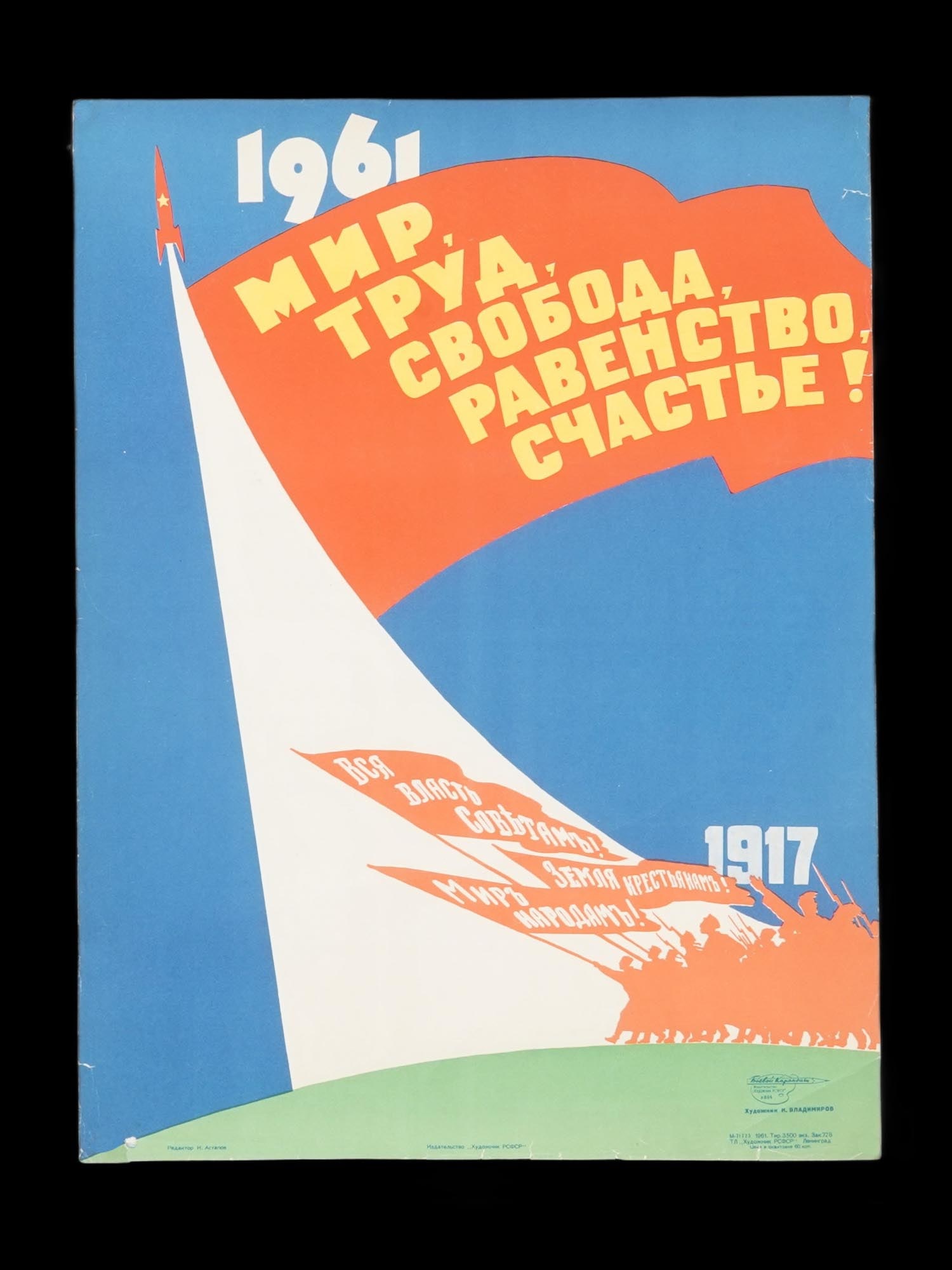 RUSSIAN SOVIET ERA PROPAGANDA POSTER: A Soviet era propaganda poster celebrates Peace, Labor, Freedom, Equality, Happiness! with a prominent orange banner against a blue sky. A red rocket, symbolizing Soviet technological advancement, soa