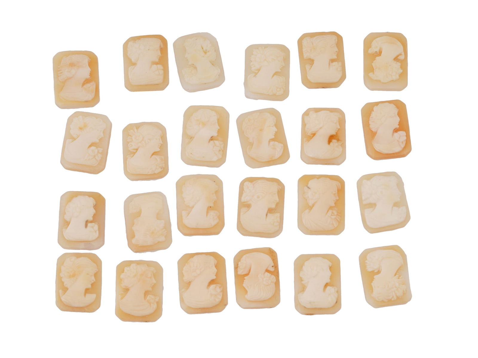 COLLECTION OF FEMALE PORTRAIT CARVED SHELL CAMEOS: A collection of hand carved shell cameos. A total of 24 items. Each piece depicts a female profile portrait rendered in high relief in the Victorian manner. Each cameo is fashioned in a distinctive oc