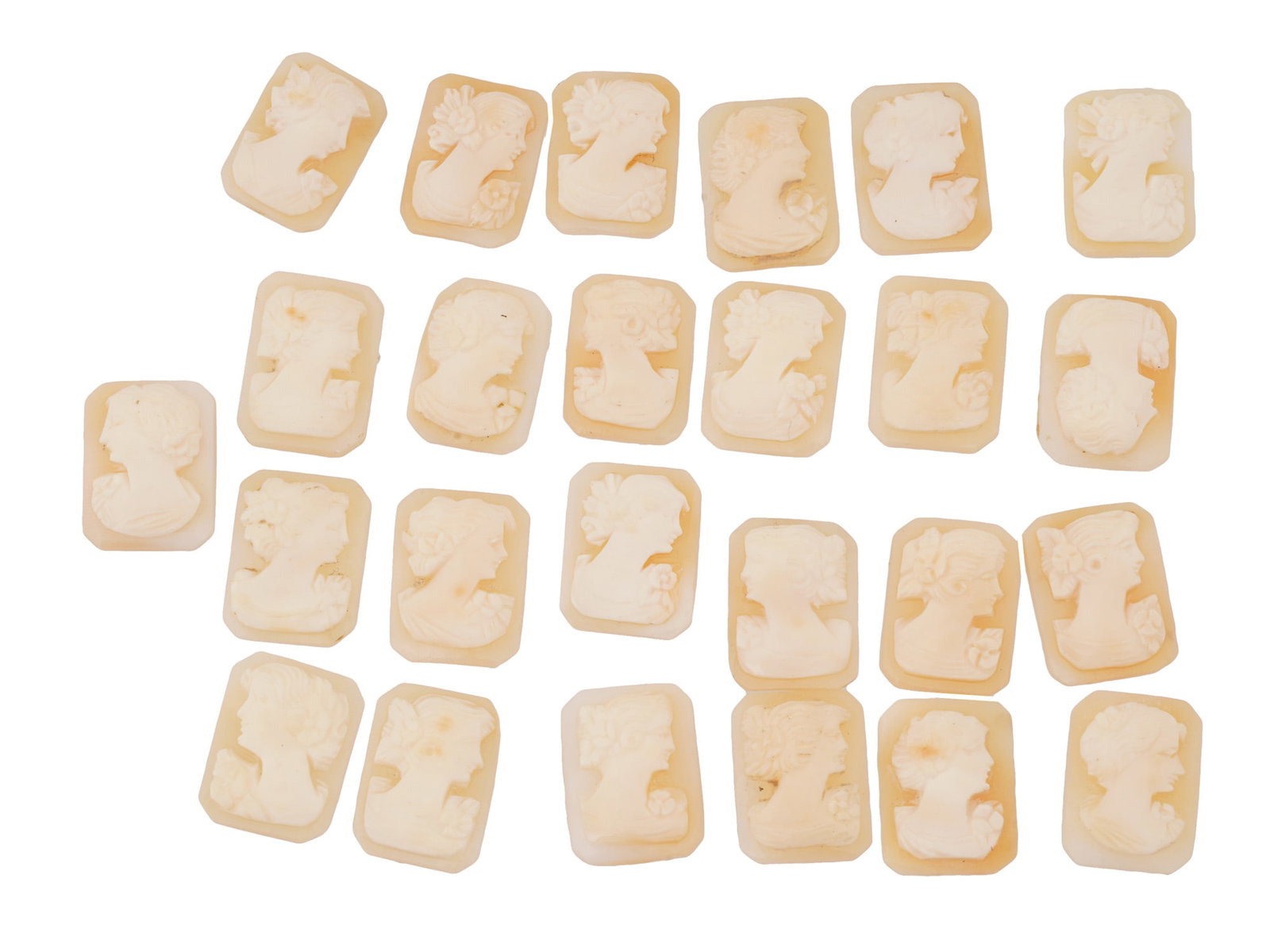 COLLECTION OF FEMALE PORTRAIT CARVED SHELL CAMEOS: A collection of hand carved shell cameos. A total of 25 items. Each piece depicts a female profile portrait rendered in high relief in the Victorian manner. Each cameo is fashioned in a distinctive oc