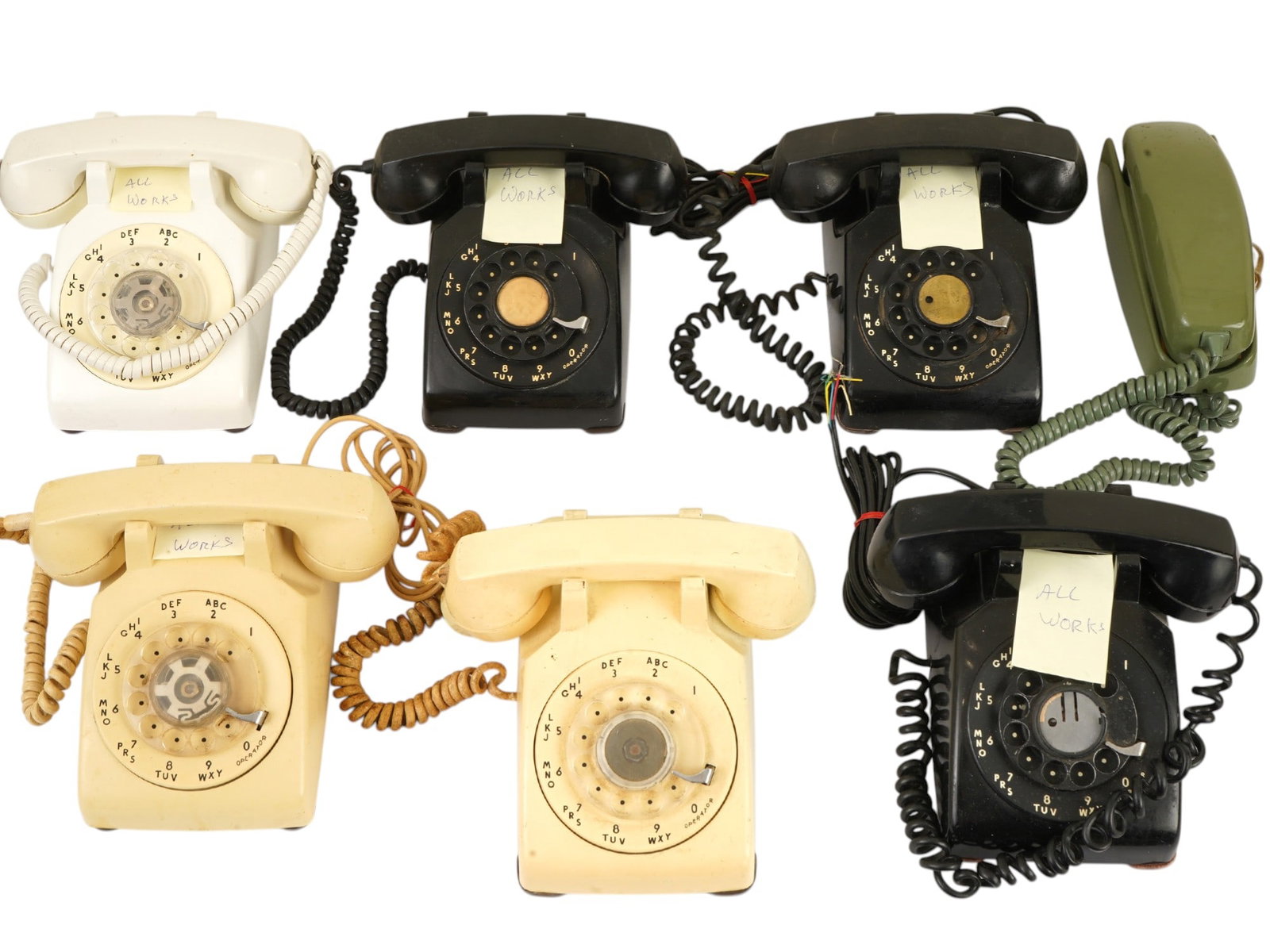 COLLECTION OF SEVEN MID CENTURY ANALOG TELEPHONES: A collection of seven mid-century analog telephones, featuring four wall-mounted units and three desk-style models in black, cream, and avocado green finishes. The assortment includes Stromberg-Carlso