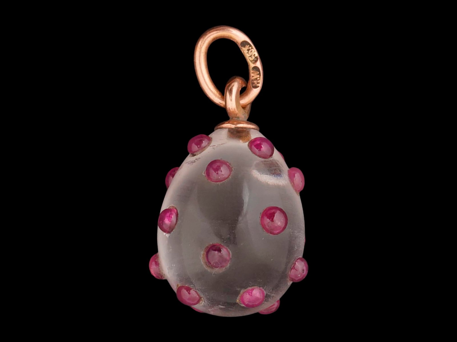 RUSSIAN 14K GOLD ROCK CRYSTAL EASTER EGG PENDANT W RUBY: A Russian 14K Gold mounted and carved Rock Crystal Easter egg pendant. The pendant is set with round cabochon cut rubies throughout the body. Marked on the fitting ring with a 56 Russian gold standard