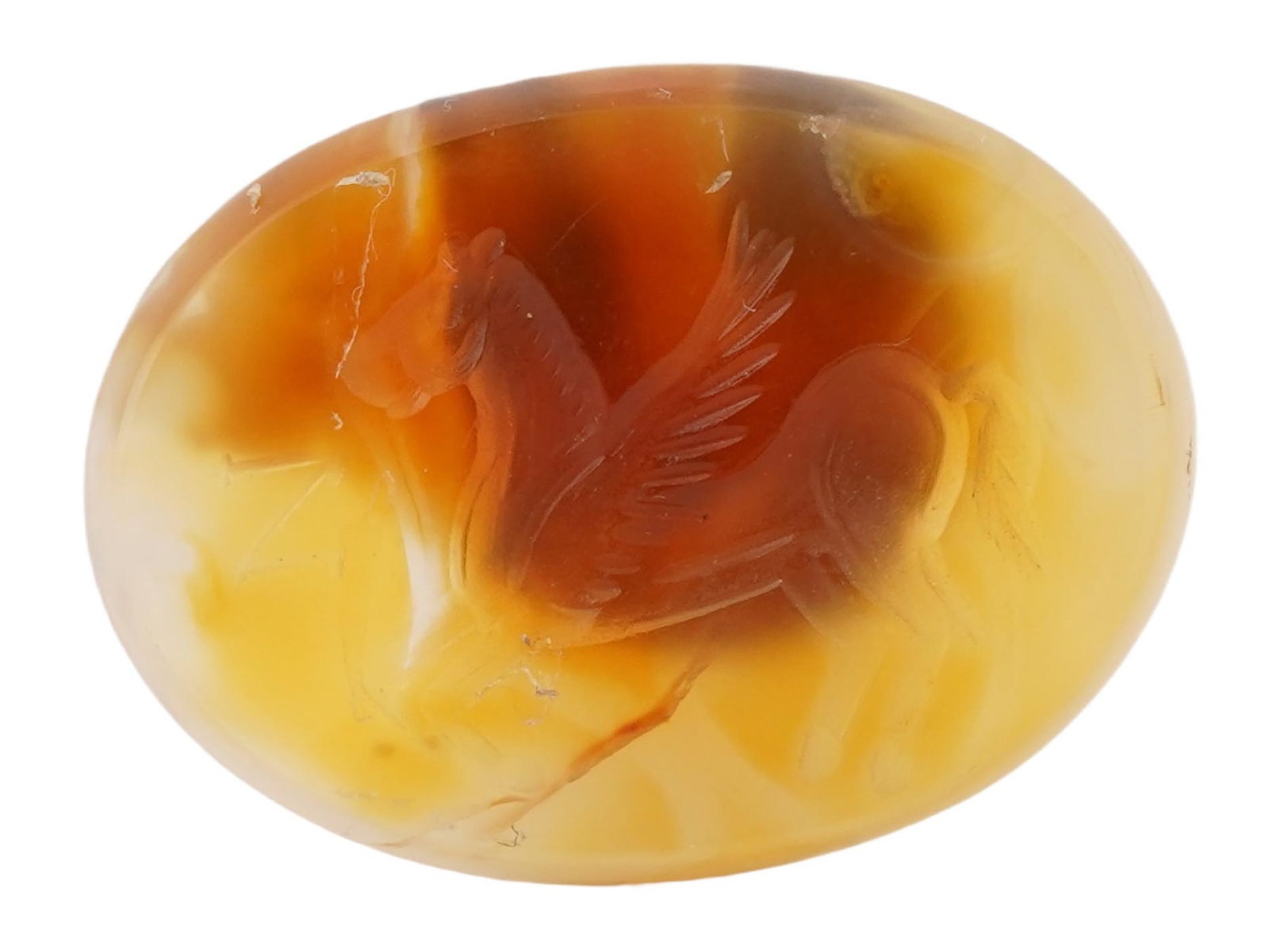 ROMAN MANNER HAND CARVED CARNELIAN STONE INTAGLIO SEAL: A Roman manner hand carved carnelian stone intaglio seal. The intaglio is adorned with an incised design representing Pegasus, a mythical horse with wings. Oval in shape. The reverse side is flat. Rom