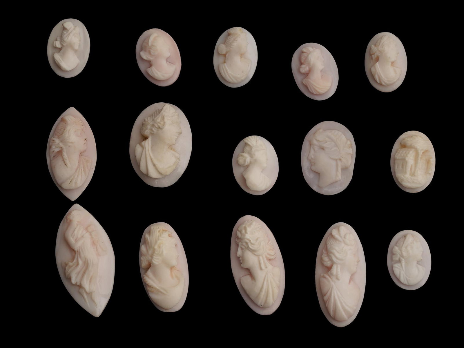 COLLECTION OF FEMALE PORTRAIT CARVED SHELL CAMEOS: A collection of hand carved shell cameos. A total of 15 items. Each piece depicts a female profile portrait rendered in high relief in the Victorian manner. Each cameo is fashioned in a distinctive ov