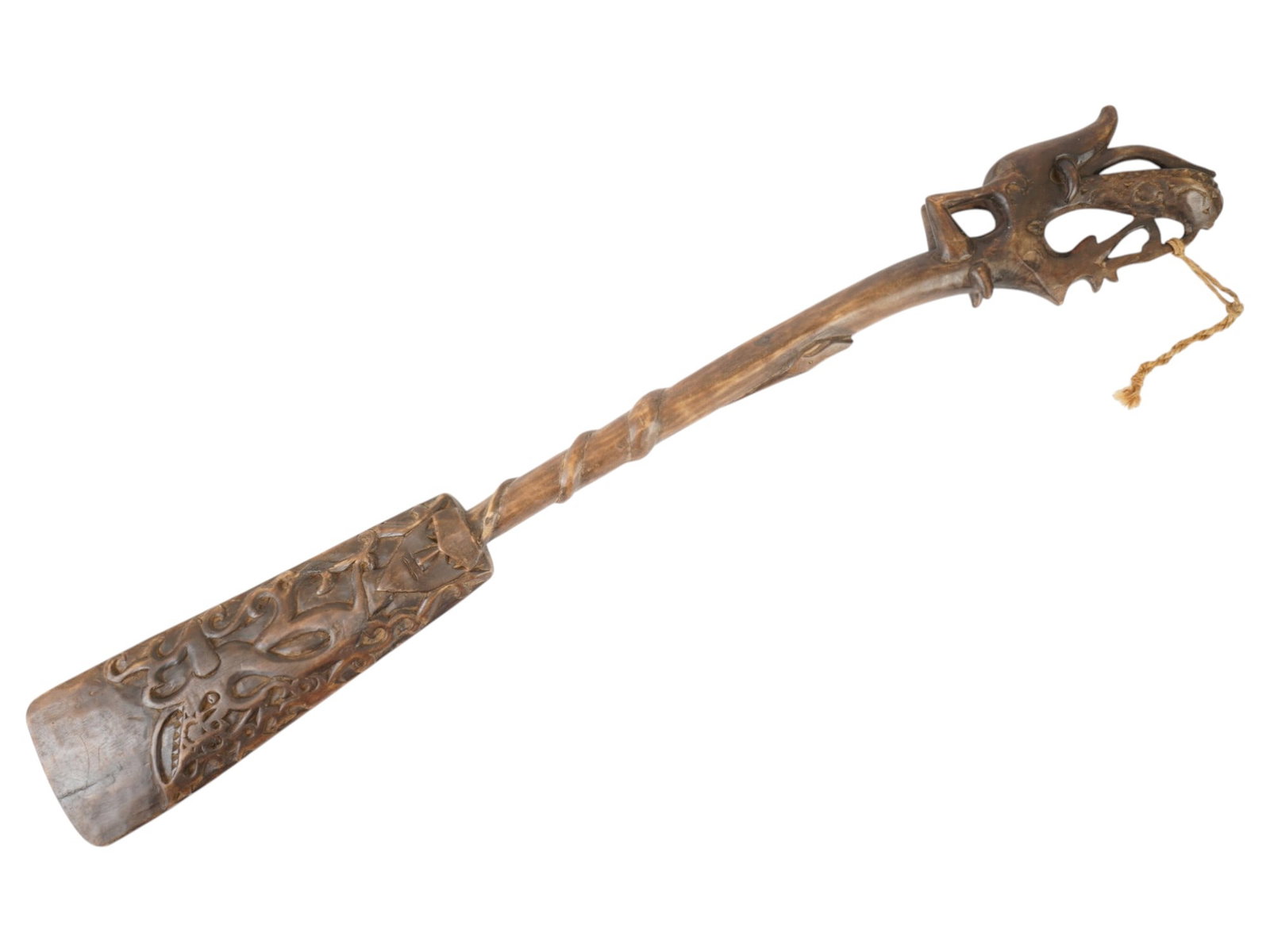 INDONESIAN DAYAK PEOPLE HAND CARVED WOODEN PADDLE: A hand carved wooden paddle originates from the Dayak people of Borneo, Indonesia, featuring intricate traditional craftsmanship. The piece is characterized by an elaborate openwork pommel depicting s