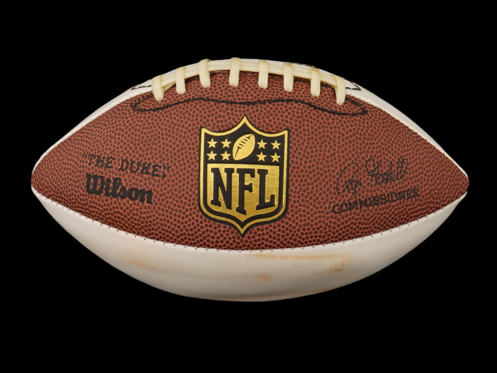 WILSON NFL AUTOGRAPHED FOOTBALL: A Wilson National Football League NFL autograph football. The ball has three white panels designed for autographs of players. Gilt NFL logo in the center. Hand inscribed and signed in blue pen. Sports
