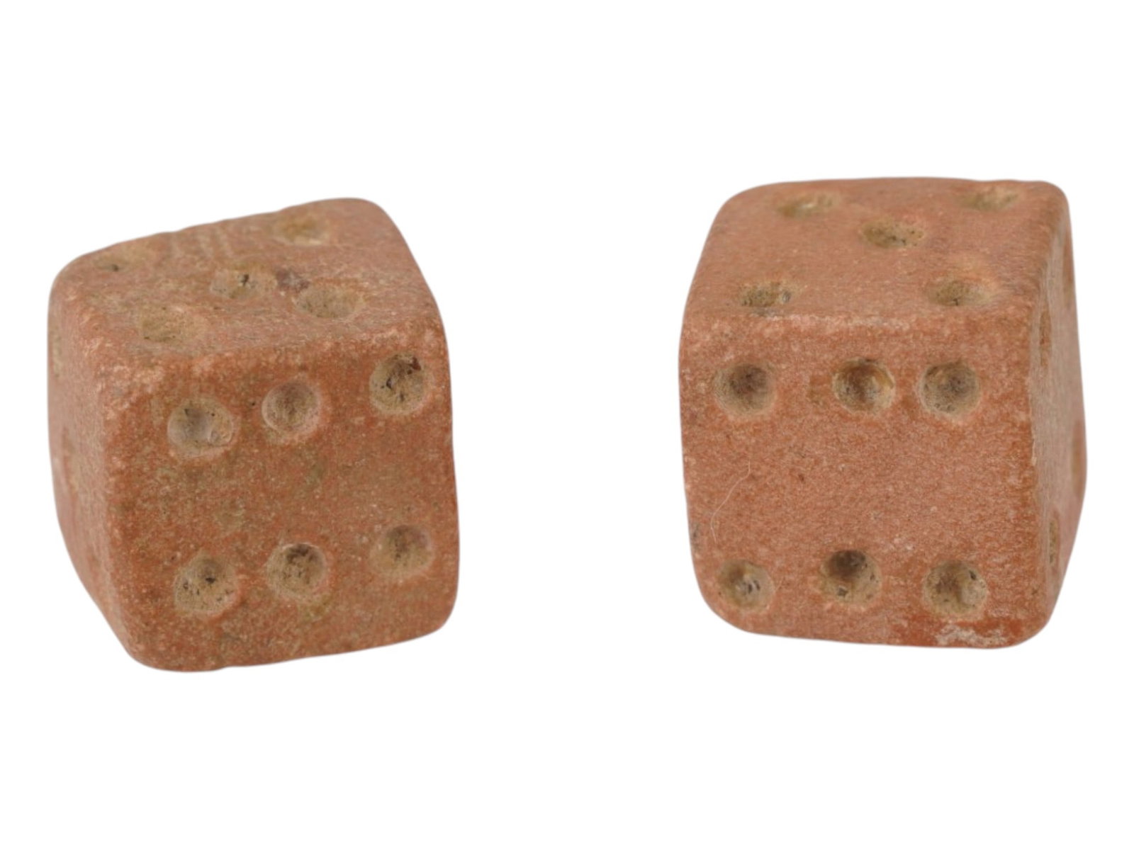 PAIR OF ANCIENT ROMAN STONE DICE 100 TO 300 AD: A pair of ancient Roman hand carved stone dice, dating from 100 to 300 AD. These artifacts offer a tangible connection to the everyday life and leisure activities of the past. Carved from stone featur
