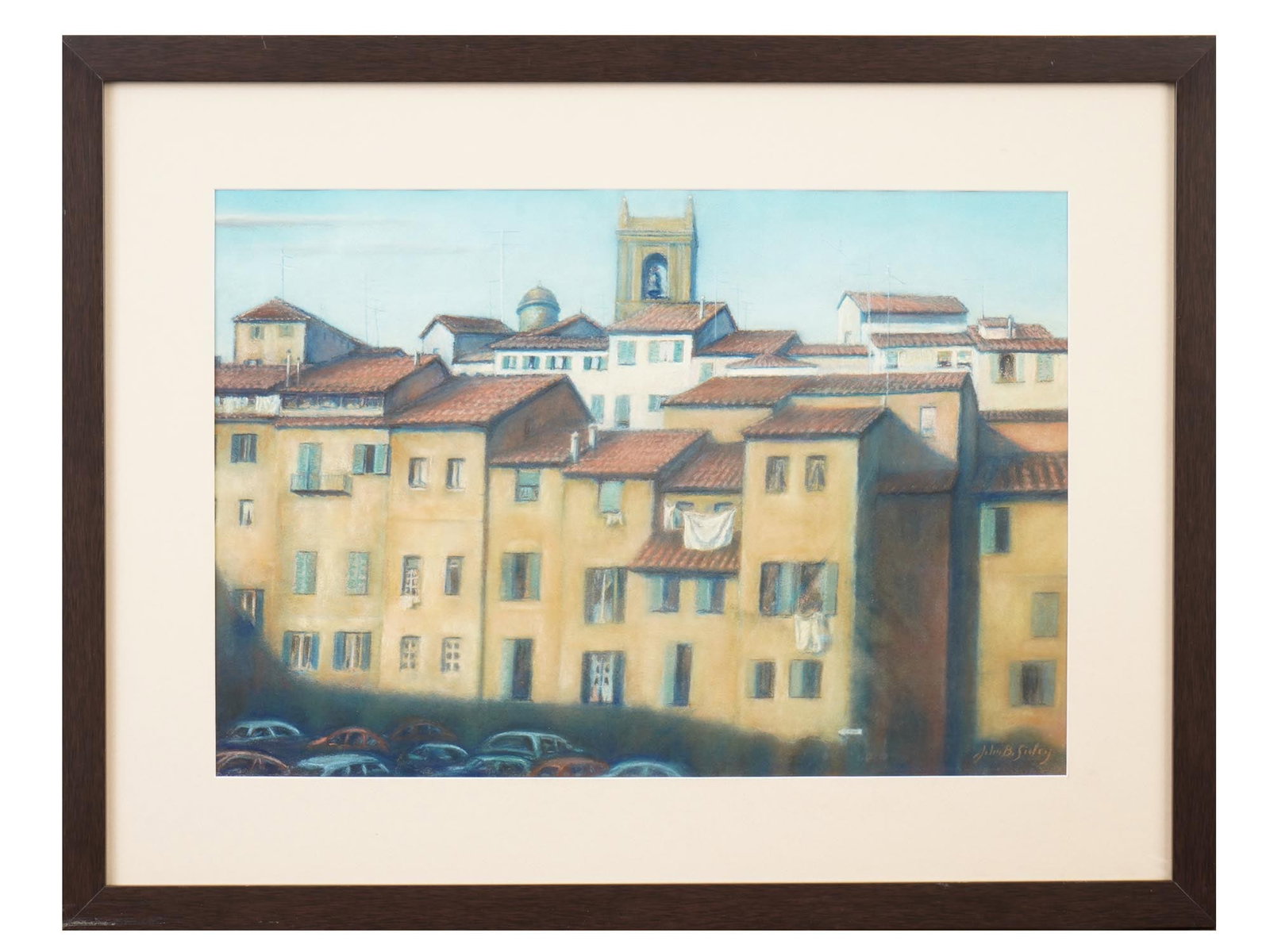 SIGNED JOHN B SISLEY ITALIAN CITYSCAPE PASTEL PAINTING: Signed John B Sisley, a pastel on paper painting depicts a sun-drenched Italian cityscape, featuring a cluster of ochre-colored buildings with terracotta tile roofs beneath a clear blue sky. The work 