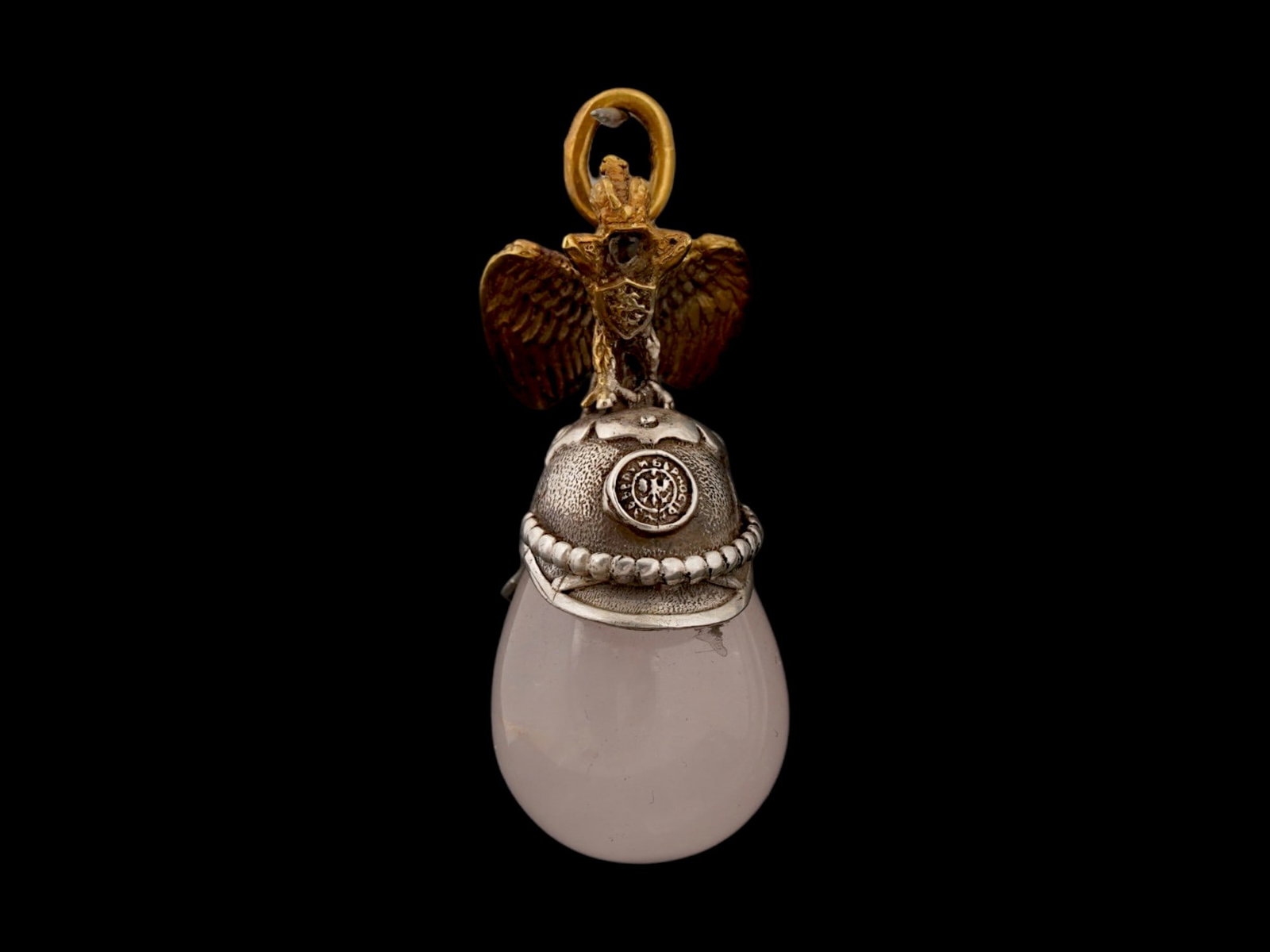 RUSSIAN IMPERIAL SILVER ROSE QUARTZ EGG PENDANT: A Russian Imperial presentation egg pendant features a body made of carved translucent rose quartz, surmounted by a detailed cast gilt silver Russian double-headed eagle with outspread wings mounted o