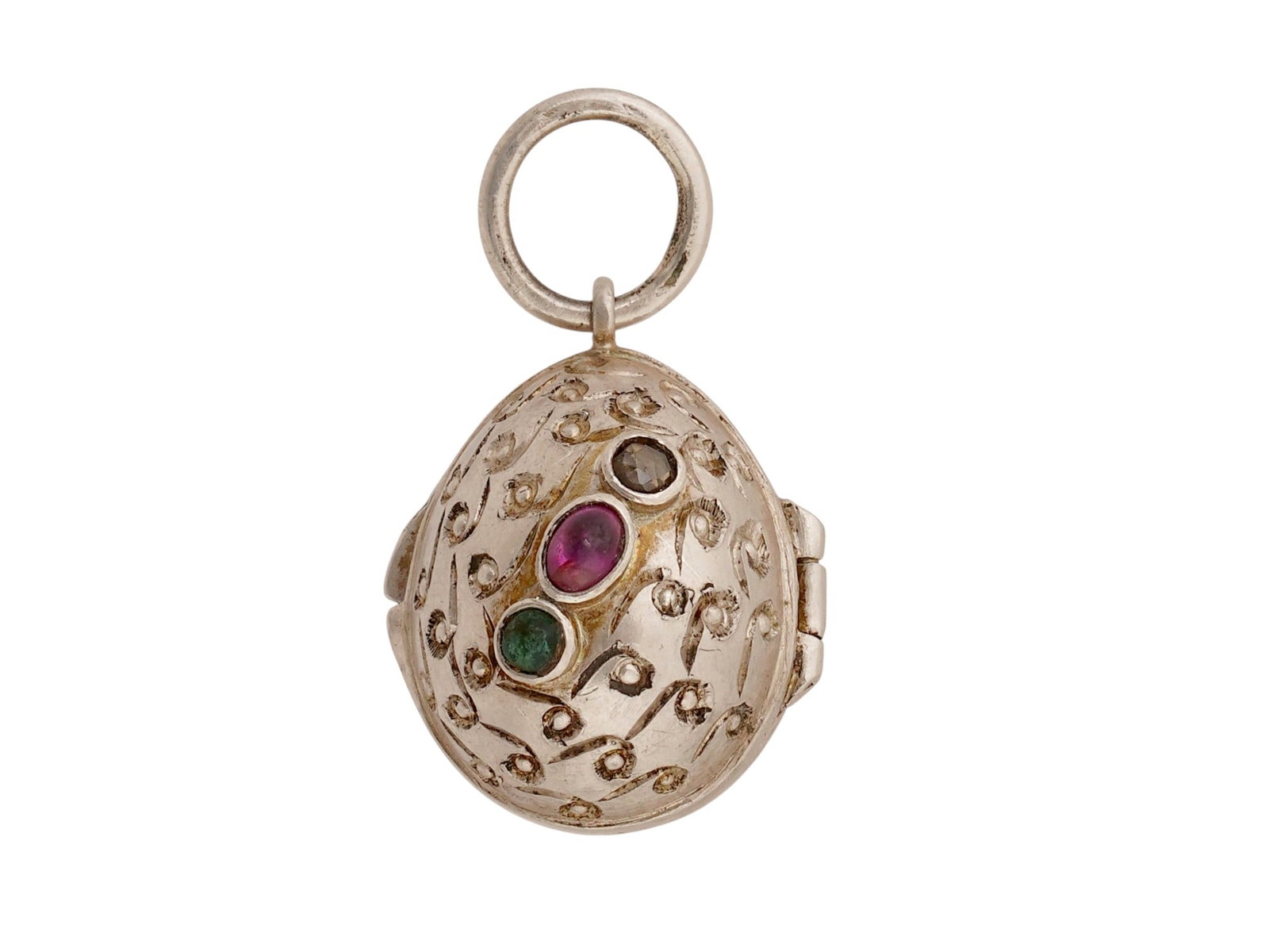 RUSSIAN SILVER EASTER EGG LOCKET PENDANT W GEMSTONES: A Russian silver Easter egg locket pendant, featuring an intricate engraved pattern throughout the exterior. The piece is set with oval-cut rubies, round emeralds, and diamonds. The interior is hollow