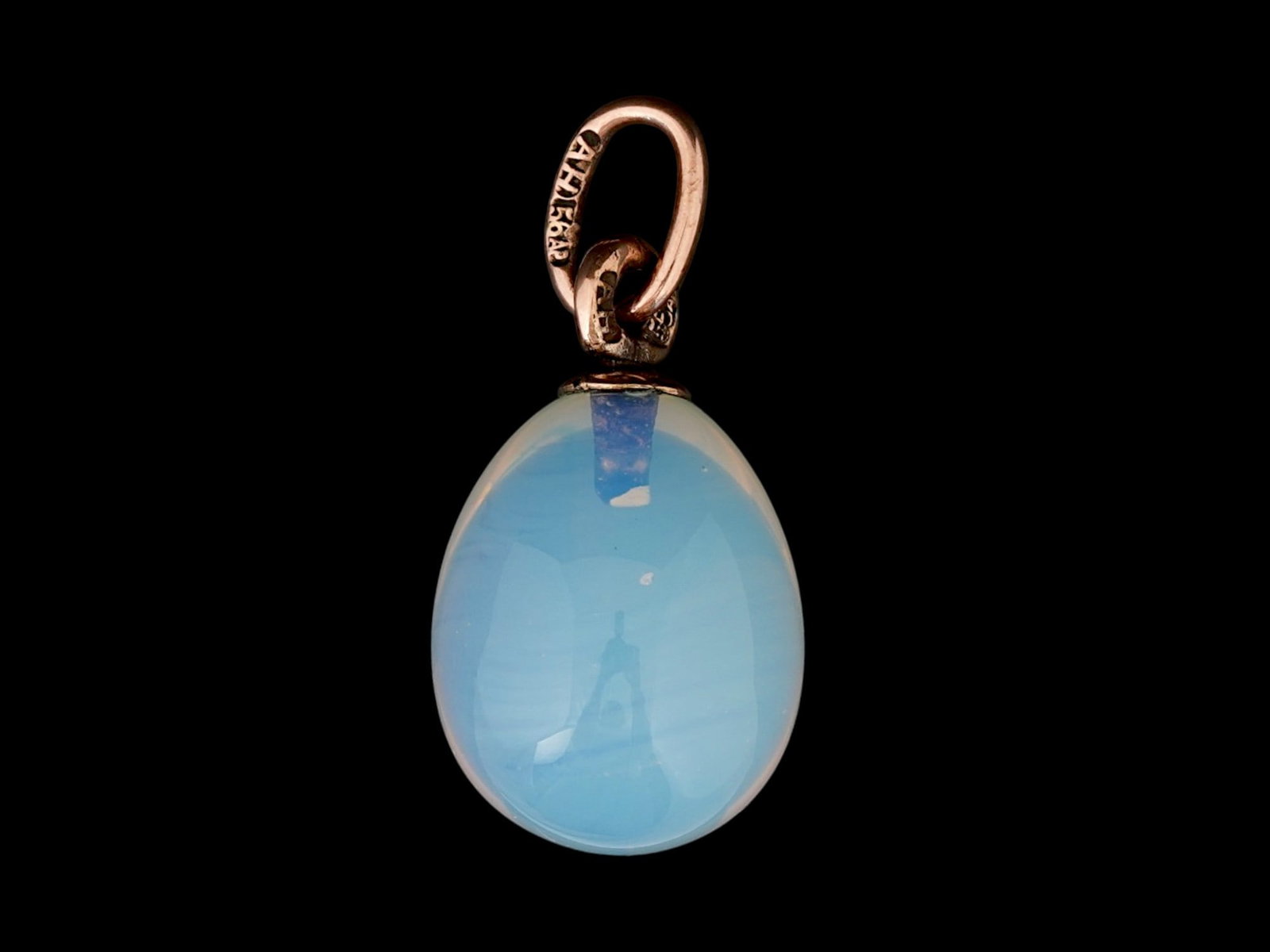 RUSSIAN GOLD AND CARVED IOLITE EASTER EGG PENDANT: A Russian carved iolite Easter Egg pendant with 14K gold fittings. Hallmark of 56 gold standard and makers mark are on the fitting ring. Total Weight: 3.3 grams. Russian Jewelry And Collectibles.