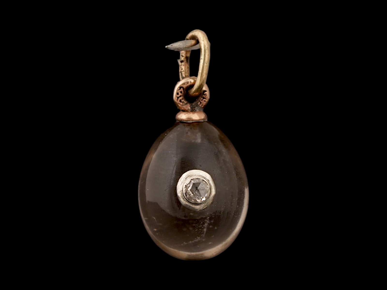 RUSSIAN GOLD SMOKY QUARTZ DIAMOND EASTER EGG PENDANT: A Russian carved smoky quartz Easter Egg pendant with 14K gold fittings. The piece is set with a diamond on the obverse. Hallmark of 56 gold standard and makers mark are on the fitting ring. Total