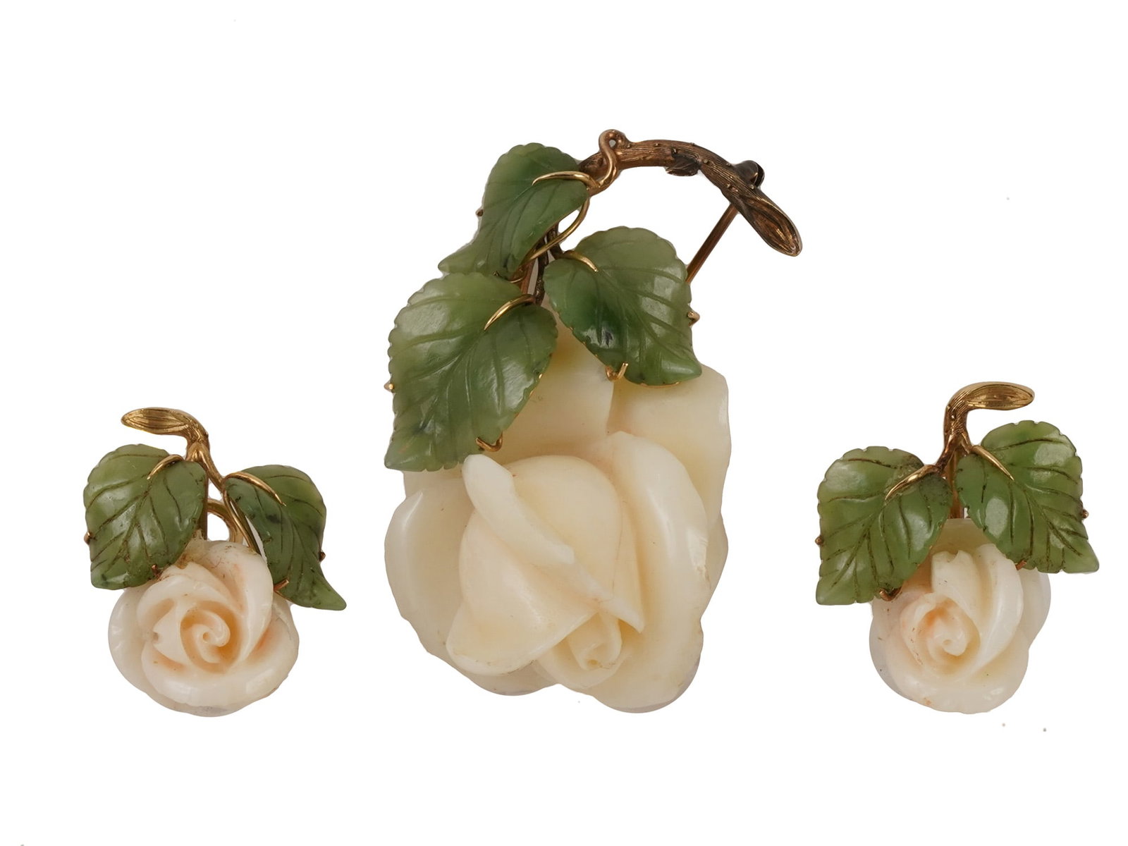 14K GOLD CORAL AND JADE BROOCH W CLIP ON EARRINGS: A vintage jewelry set made of 14k gold, coral, and jade, including a brooch and a pair of clip-on earrings. All pieces are shaped like white roses topped with carved jade leaves in a 14-carat gold