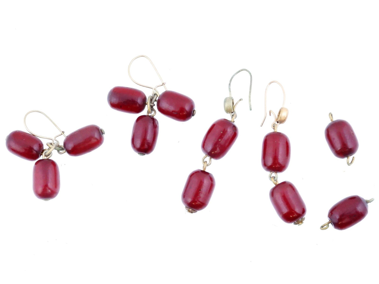 LOT OF TWO PAIRS OF NATURAL AMBER BEAD EARRINGS: A lot of two pairs of amber bead earrings with two single amber beads. The earrings feature smooth, barre shaped beads of a deep red color, likely Baltic amber. One pair of earrings have three amber