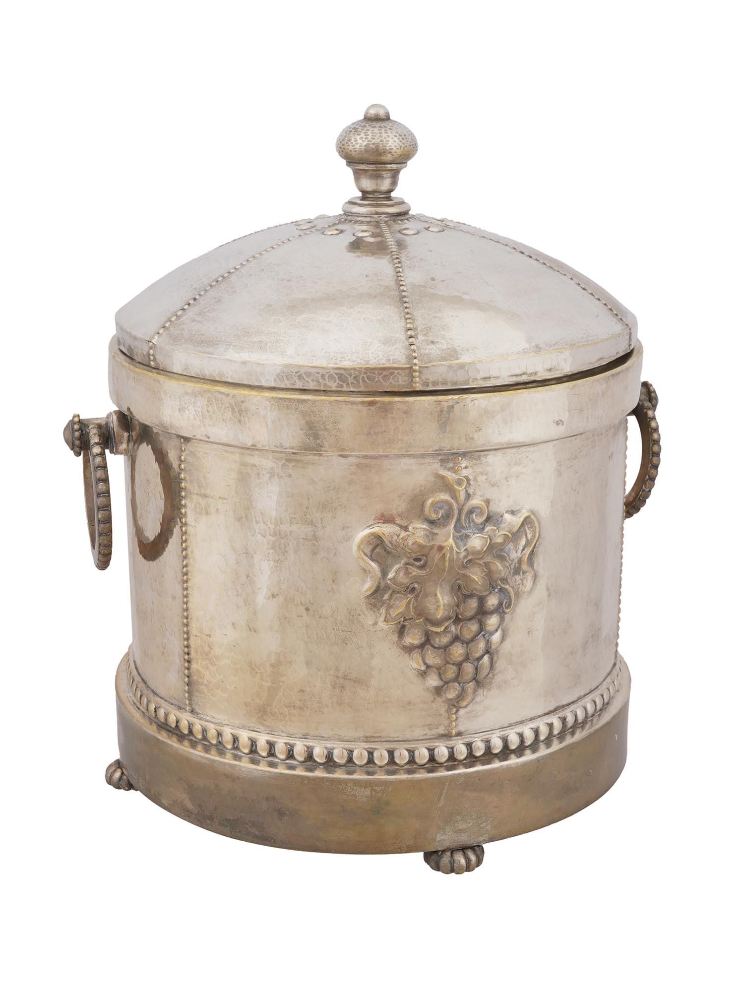 ANTIQUE SILVER PLATED ICE BUCKET WITH GLASS INSERT: An antique silver-plated ice bucket featuring a glass insert and a lid adorned with a figural finial. The bucket is decorated with relief grape motifs and a beaded lower rim. Has two handles for easy 