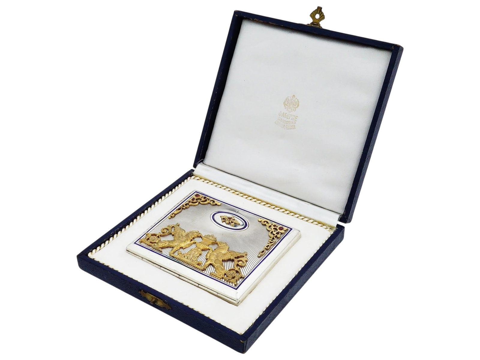 RUSSIAN SILVER CIGARETTE CASE WITH GARNETS IOB: A Russian silver cigarette case featuring an engine-turned sunburst ground on both the obverse and reverse. The front cover is embellished with applied gilt silver foliate corners set with garnets and