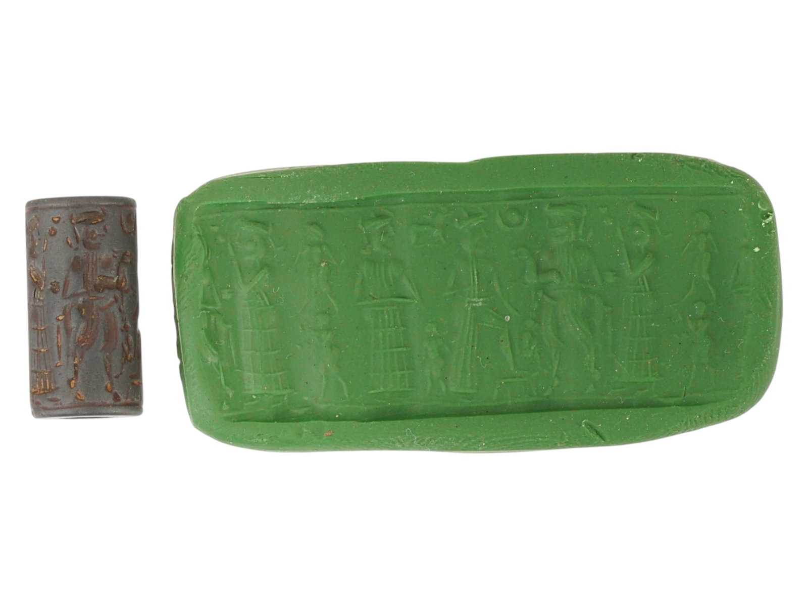 ANCIENT HOLY LAND CYLINDRICAL STEATITE STAMP SEAL: An ancient Holy Land cylindrical steatite stamp seal, dating ca. circa 1st millennium BC. The dark stone block is engraved on all sides with stylized ritual figures. A longitudinal drill hole through 
