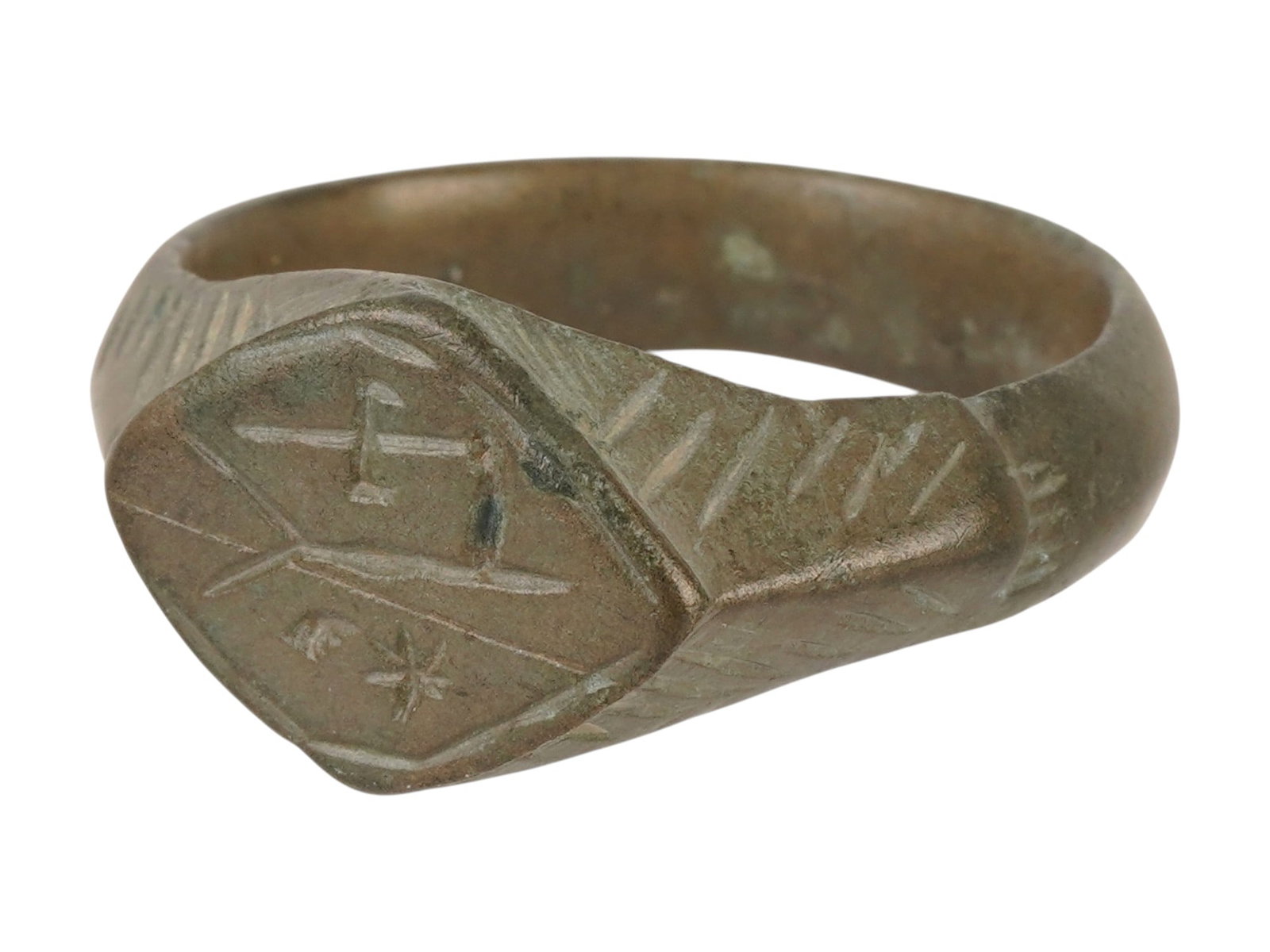 HUGE ANCIENT BYZANTINE BRONZE SIGNET RING 400 TO 600 AD: A huge ancient Byzantine bronze signet ring, dating circa 400 to 600 AD, features a characteristic lozenge-shaped bezel deeply engraved with a central cross and geometric flourishes. The shoulders are