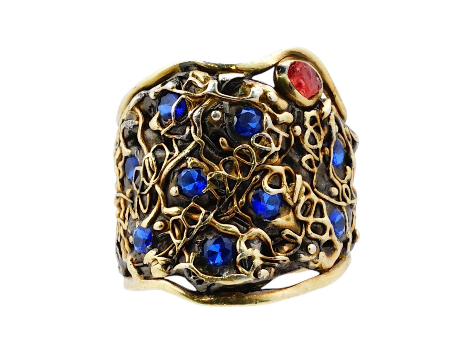 CHKHIRA JEWELRY SILVER AND GOLD RING: A wide-band artisan ring by Chkhira Jewelry is crafted in sterling silver with gold highlights, featuring a complex organic openwork structure. The design is embellished with numerous round blue stone