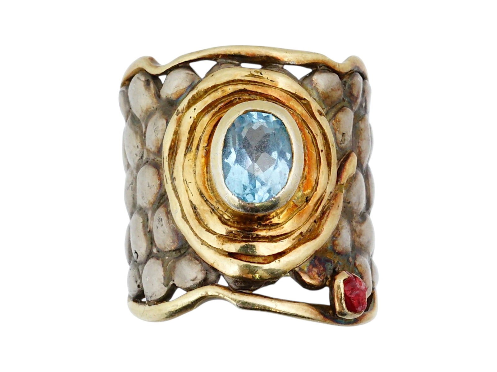 CHKHIRA JEWELRY SILVER AND GOLD WITH GEMSTONES RING: A wide-band artisan ring by Chkhira Jewelry ring features a mixed-metal construction of sterling silver and yellow gold accents. The design centers on a bezel-set oval blue topaz framed by concentric 