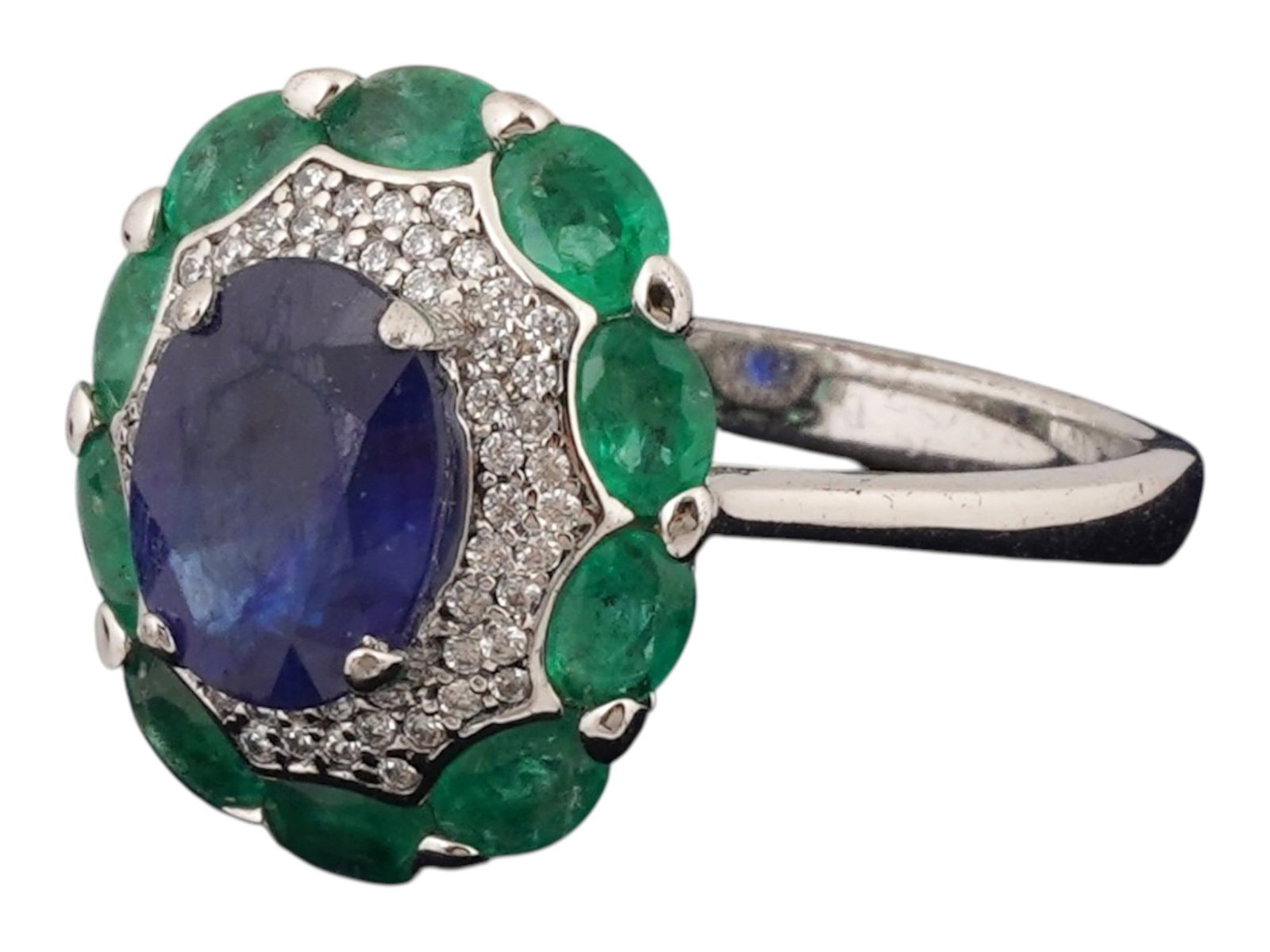 STAUER SAPPHIRE EMERALD STERLING SILVER RING IOB: A vintage sterling silver cocktail ring by Stauer. The central oval-cut African sapphire is encompassed with a row of crystals and smaller oval-cut emeralds. Marked 925, Stauer on the inside. Total We