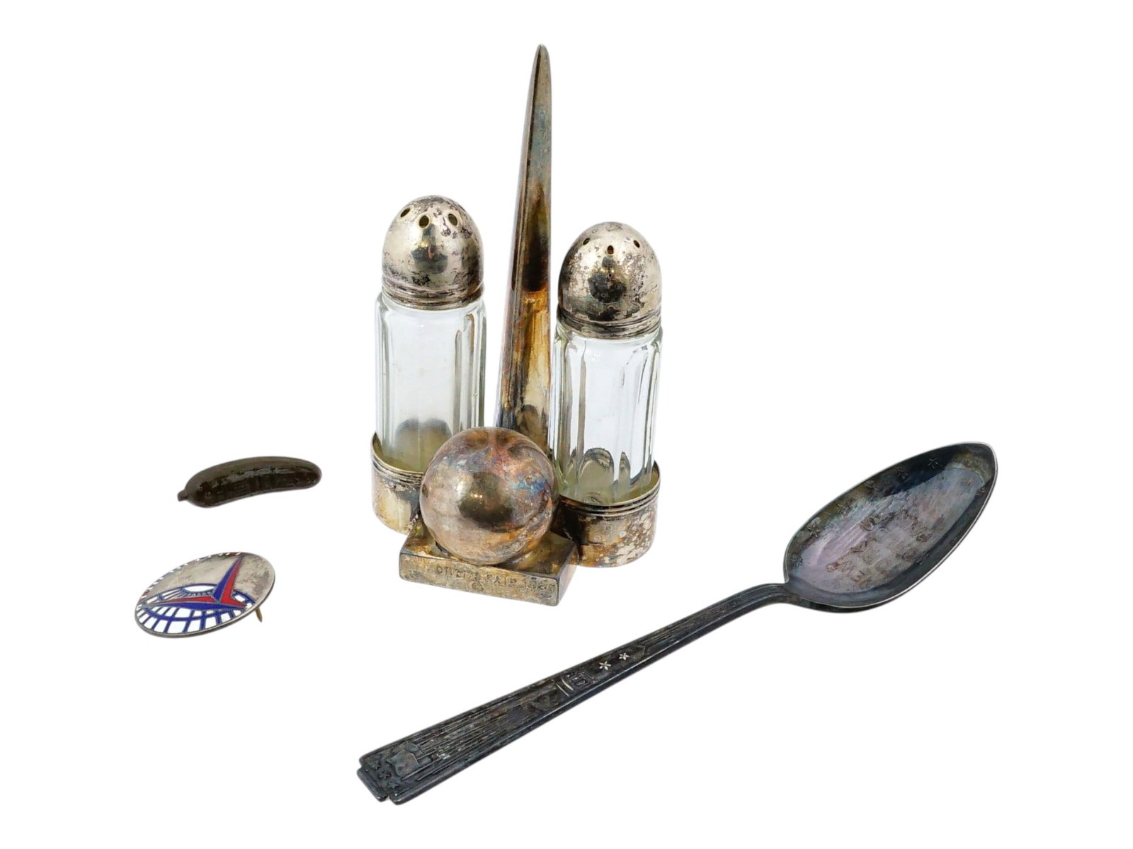 GROUP OF SOUVENIRS FROM 1939 NEW YORK WORLDS FAIR: A collection of vintage souvenirs from the historic 1939 New York Worlds Fair, featuring the fairs iconic Trylon and Perisphere architectural motifs. The group includes a silver-plated salt and pepper