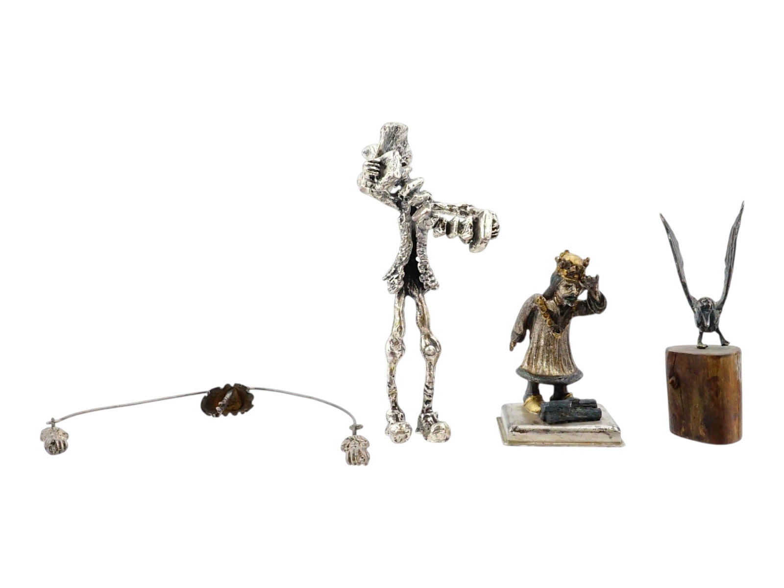 GROUP OF FOUR STERLING SILVER FIGURINES: A group of four sterling silver figurines features a balancing dancer figure, a surrealist tall musician, a miniature king on a base, inscribed made in England and a bird figurine perched on a wooden 