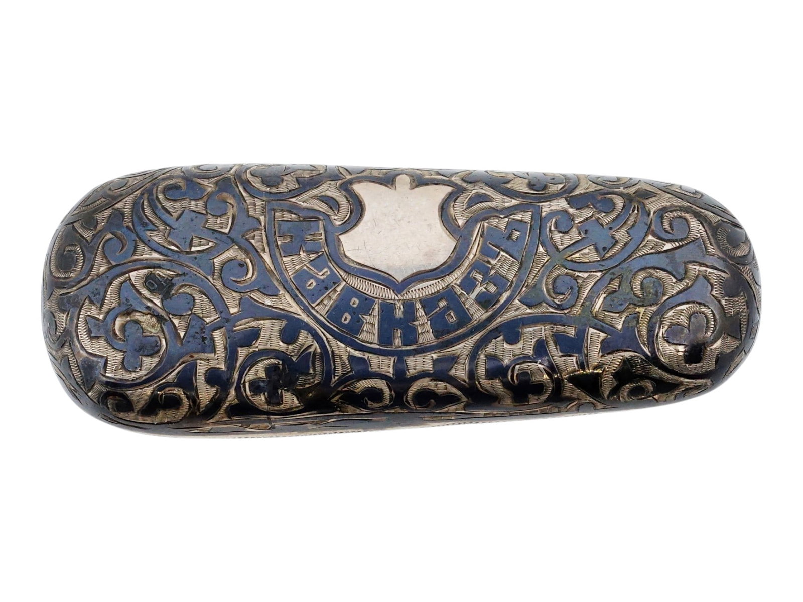 ANTIQUE RUSSIAN CAUCASIAN SILVER NIELLO COIN HOLDER: An antique Russian Caucasian silver coin holder is decorated with traditional niello work featuring a dense arrangement of scrolling foliate and geometric motifs. The top face includes a vacant shield