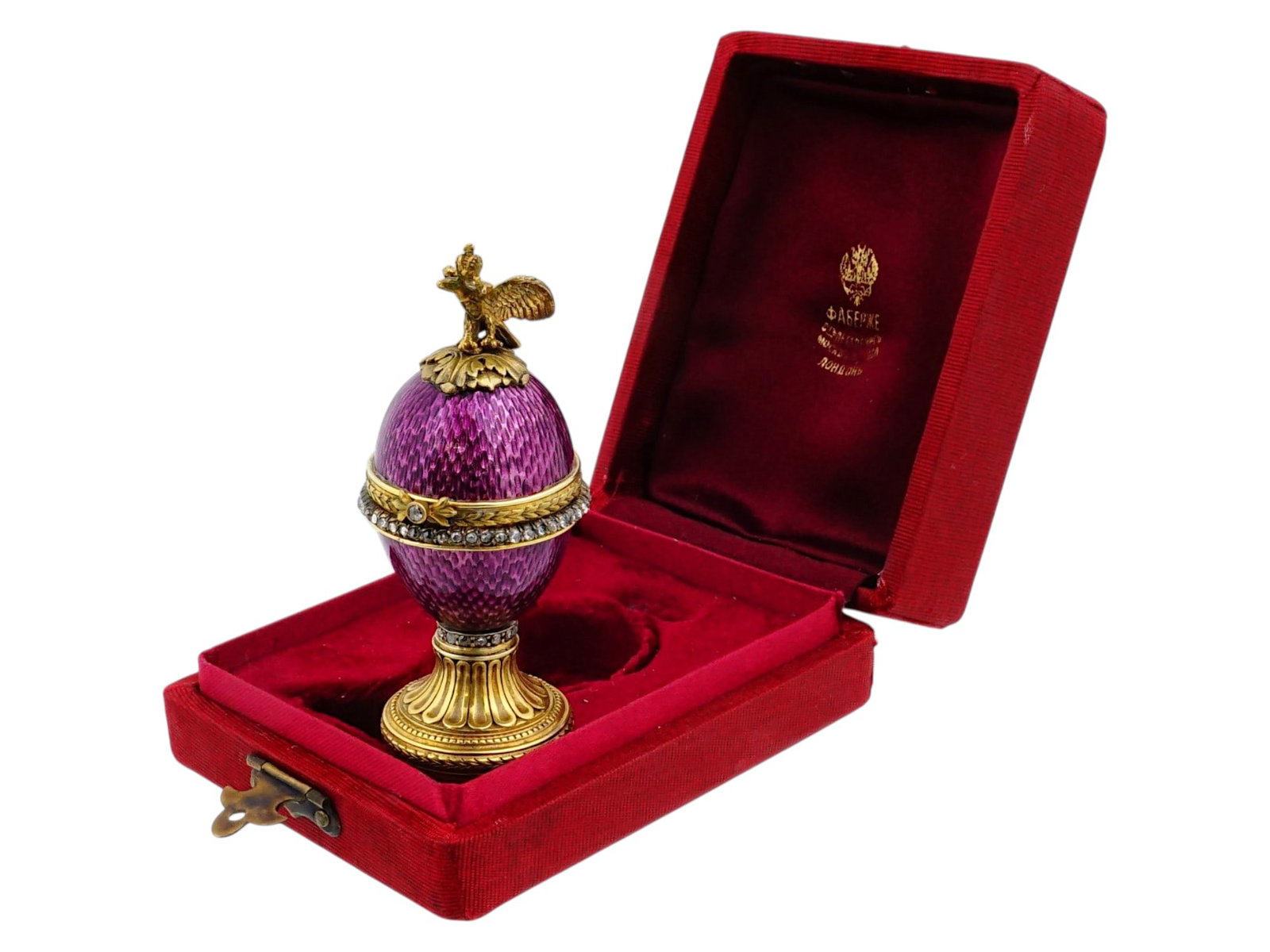 RUSSIAN GILT SILVER GUILLOCHE ENAMEL EASTER EGG: A miniature Russian gilt silver footed Easter Egg casket with hinged lid. The piece is garnished with purple guilloche enamel and diamonds. Imperial Eagle finial. A mouse figurine is set inside. Hallm