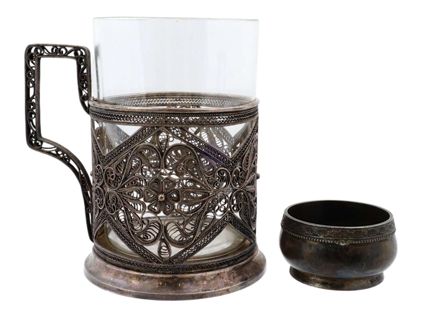 RUSSIAN SOVIET ERA SILVER SALT CELLAR AND GLASS HOLDER: A Russian Soviet era silver-plated handled tea glass holder or podstakannik. Filigree ornamental decor. Comes with a glass. Hallmark KKhI for Kazakovskoye Khudozhestvennoye Izdeliye. The lot also