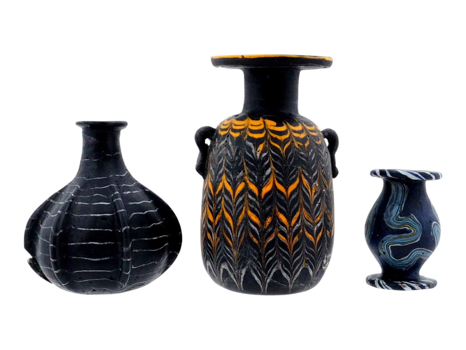 ANTIQUE GRAND TOUR PHOENICIAN MOSAIC GLASS VASES: A lot of three antique 19th-century mosaic glass items, reproductions of Phoenician vases made for sale as a Grand Tour souvenir. Each vase has a distinct design, varying in shape and pattern against 