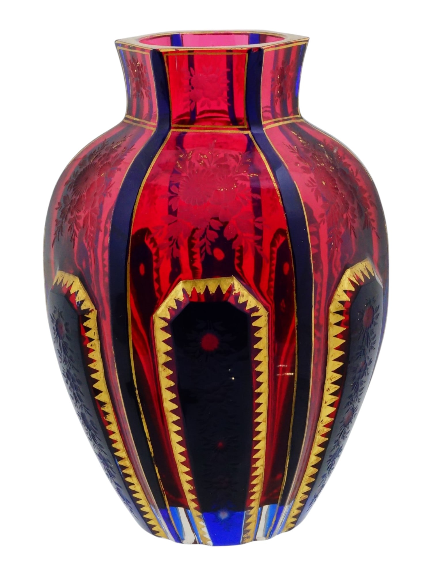 ANTIQUE ENGLISH VICTORIAN CRANBERRY GLASS VASE: An antique English Victorian cranberry glass vase. The vase is made using the cased glass technique, with alternating panels of ruby ??red and cobalt blue colors. The panels are accented by gilt zigza