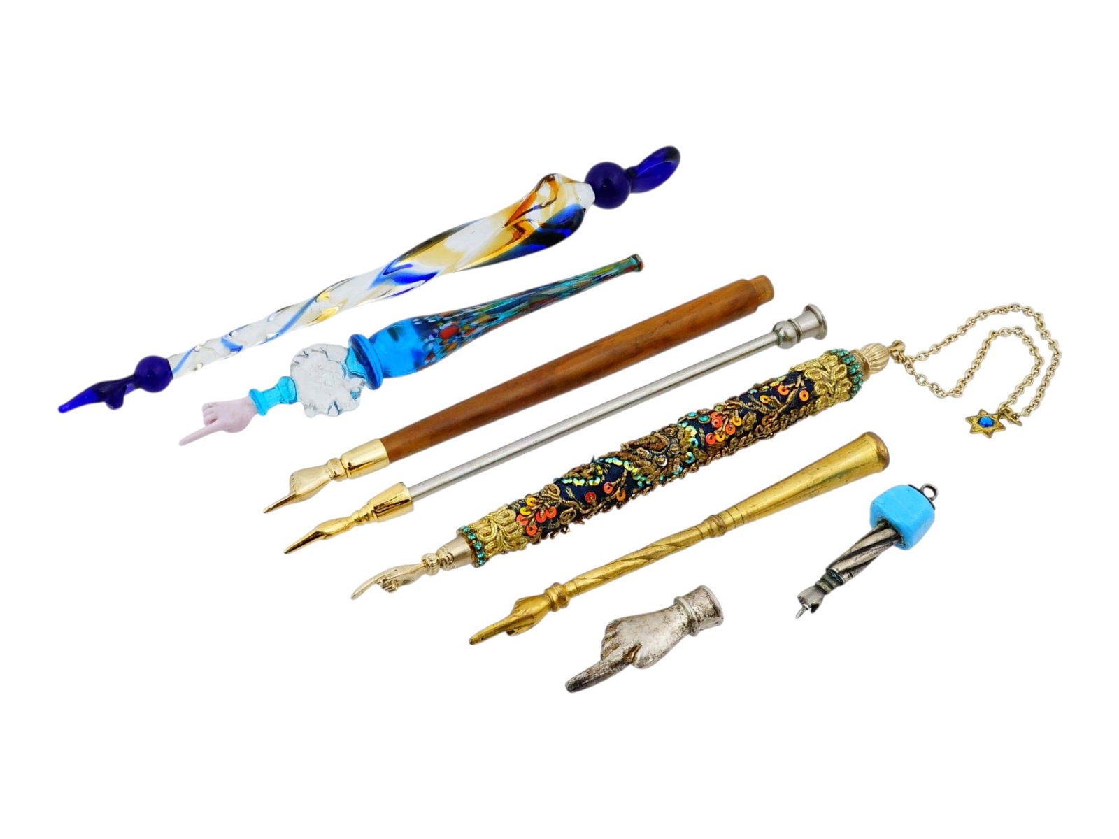 COLLECTION OF SEVEN VINTAGE JUDAICA TORAH POINTERS: A diverse collection of seven vintage Torah pointers, or yads, traditional Judaica ritual objects used to follow sacred Torah text without direct contact. The group includes colorful glass examples, s